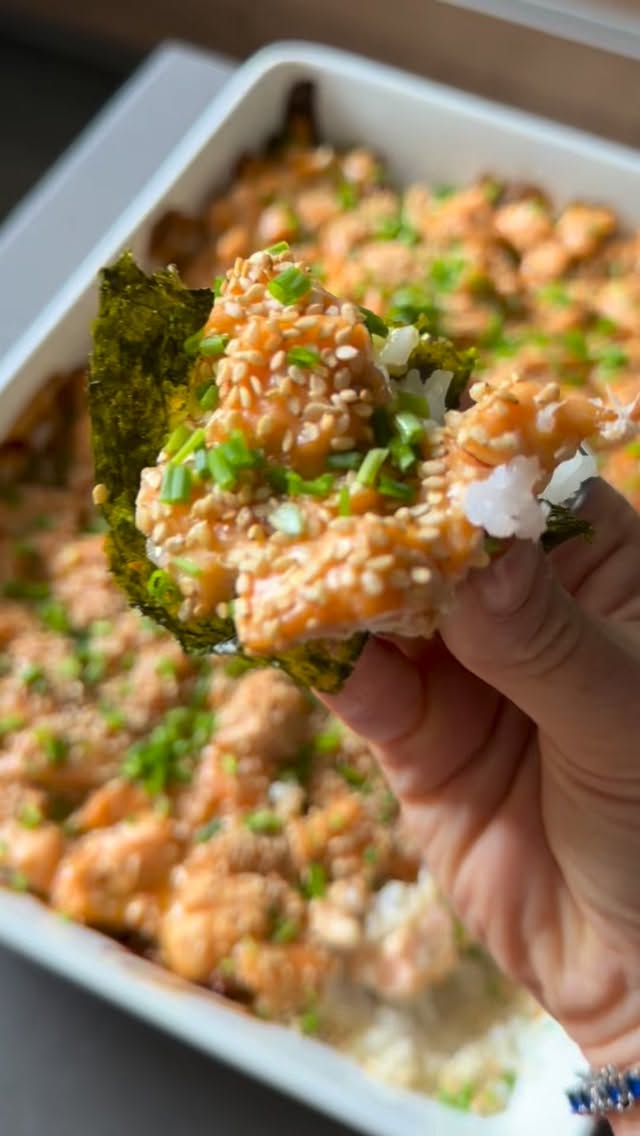 SUSHI BAKE DE SALMÓN CON MISO
Rinde: 6–8 porciones
Ingredientes
• 2 tazas de arroz para sushi crudo
• Agua para cocinarlo, según las indicaciones del empaque
• 1 kg de salmón sin piel, cortado en cubitos
• ¼ de taza de salsa de soya
• 2 cucharadas de miel de maple
• 2 cucharadas de miso blanco
• ½ cucharadita de ajo en polvo, o al gusto
• 1 cucharada de vinagre de arroz
• 1 cucharadita de aceite de ajonjolí
• Jugo de 1 limón
• Cebollín picado, al gusto
• Hojas de alga nori cortadas en cuadros, para servir
Preparación
1. Enjuaga el arroz varias veces con agua fría, hasta que el agua salga casi transparente. Escúrrelo y colócalo en una olla con la cantidad de agua indicada en el empaque. Lleva a hervor, tapa, baja el fuego al mínimo y cocina aproximadamente 15–20 minutos, sin destapar. Apaga y deja reposar tapado 10 minutos.
2. Mezcla la salsa de soya, la miel de maple, el miso blanco, el ajo en polvo, el vinagre de arroz, el aceite de ajonjolí y el jugo de limón.
3. Vierte la mezcla sobre el salmón y deja marinar durante 20 minutos en el refrigerador.
4. Precalienta el horno a 200 °C. Extiende el arroz cocido en un refractario y distribuye encima el salmón con su marinada.
5. Hornea aproximadamente 25 minutos, hasta que el salmón esté cocido. Para dorar la superficie, puedes terminar con unos minutos de grill, vigilando que no se queme.
6. Termina con cebollín y lleva a la mesa con los cuadritos de alga nori para que cada quien arme sus taquitos al momento.
Guárdalo para cuando tengas antojo de sushi en casa y dime: ¿qué topping no puede faltar en tu taquito?