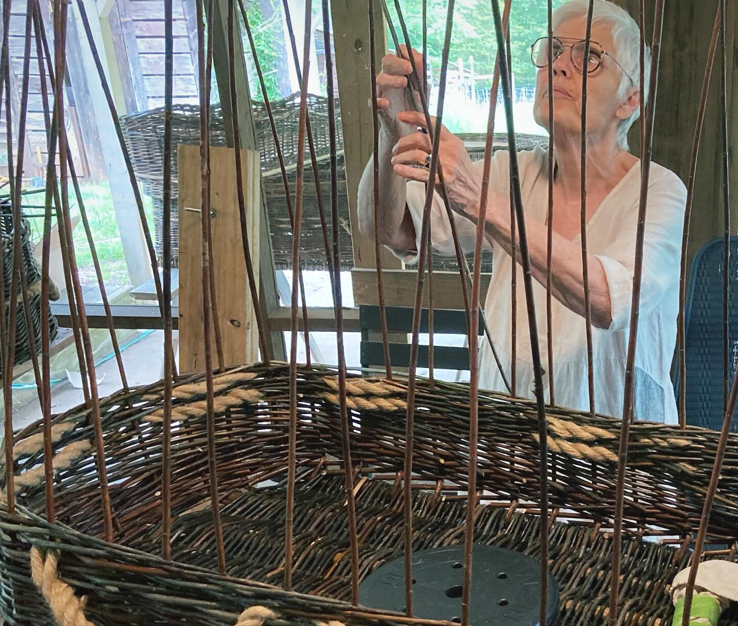 U weaving her burial tray♥️. This photo is the only one of her alone, for in reality the screened porch was full of her dear friends, who gathered for the week to join her in both weaving her tray and making plans for her final days and burial. It is also a rare capture of serious expression, because most of the days were full of laughter and joyful tears, and singing, and toasting with her favorite brandy. Those photos will follow! But this one I love, because it captures the seriousness and the sacred that ran underneath, her dedication to every detail—the curve of the basket, the twining of the handles, the contrast between wood and willow colors. Her artist’s eye and her fierce brave heart.
Today she is out swimming in the ocean in Thailand, her burial tray hanging @the_gallery_at_morning_star so others can share in her journey, and I’m thinking about the bravery it takes to fully live.
#communitydeathcare #naturalburial #willowcasket #shroud #burialtray #greenburial #endoflifeplan #funeralplans #deathdoula #homefuneral #fivewishes #carolinamemorialsanctuary #circleoflove #handmade #handwoven #wheniamanoldwoman #facingfear #wncmountains #mossandthistlefarm #handmadecasket