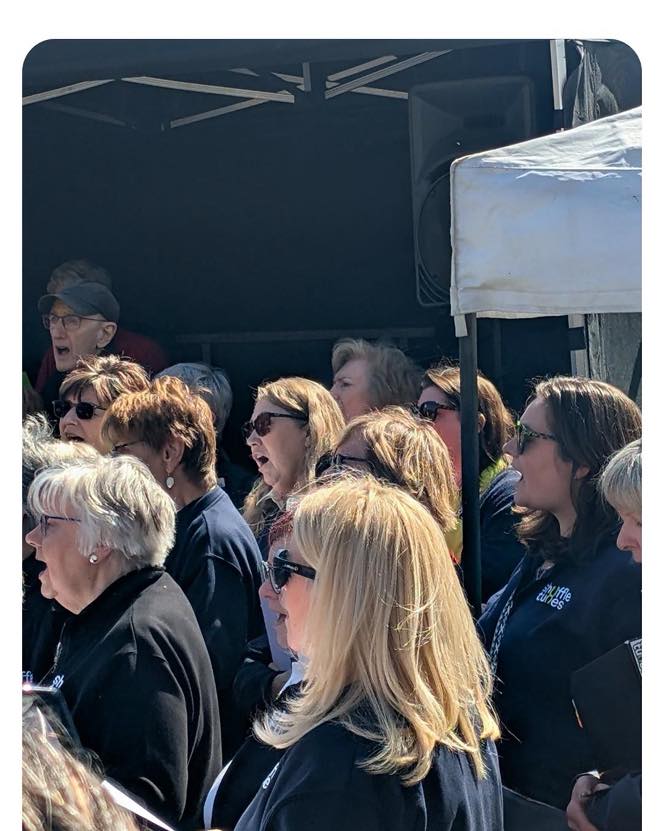Thank you to Vicky Goode and all at Surrey hills enterprises for yesterdays sing! We beat the clouds and had great fun singing with the crowd. And we even had some girls who didn’t know the songs but wanted to be with you come and sing! You gave a strong sense of belonging. It was so good. Great photo here from Liz’s friend- just such a happy occasion! It’s a real privilege to sing at these events at amazing venues. Thanks also to Gavin for the fantastic sound!