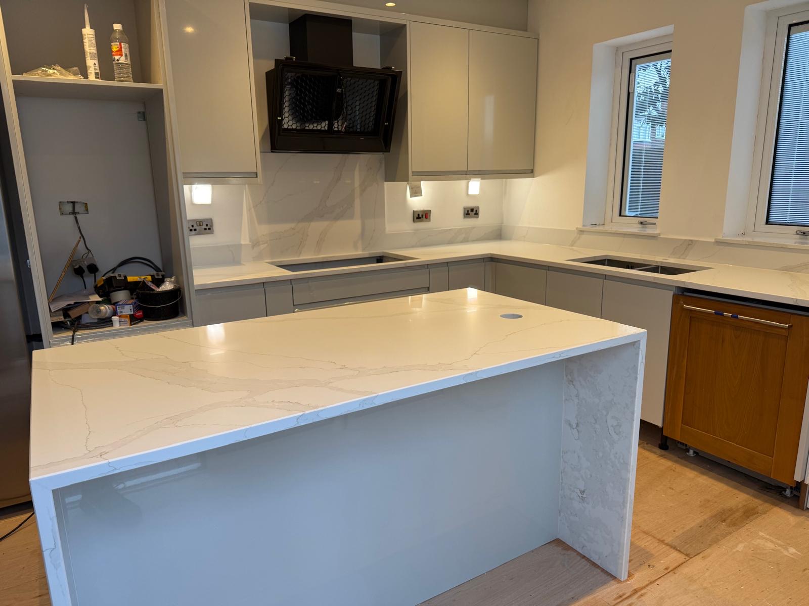 Calacatta Oro tops with waterfall end panels, hob splashback and window sills #homeimprovement #worktopscheshire #quartzworktops #quartzworktop #kitchenideas #kitchenworktops