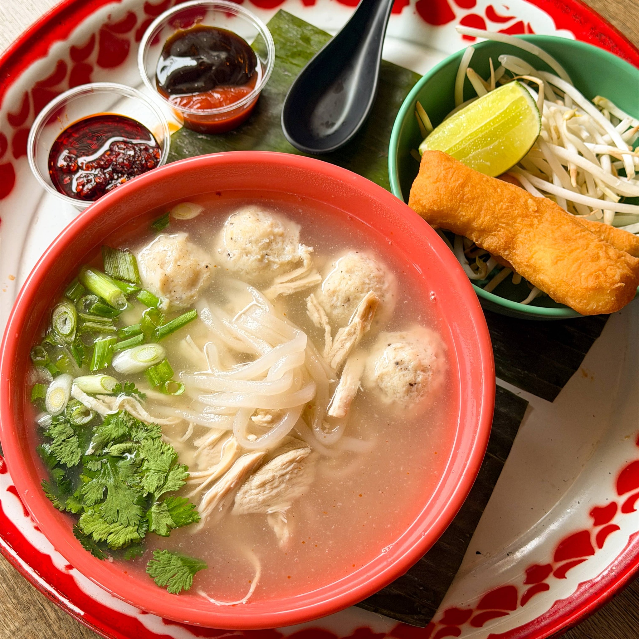🍜 New Item Alert: Khao Piek Pho 🍜
Limited Time Special: We've combined two traditional noodle soups into one!
Homemade chicken broth, thick rice noodles, shredded chicken breast, tender house-made chicken meatballs. Topped with scallions, cilantro, bean sprouts, lime, and a Pa Tong Ko bread stick. The chewy bread stick dipped in this broth is a moment in comfort food heaven. Served with a side of sriracha and hoisin.
Available for a limited time or until sold out 💚🧡