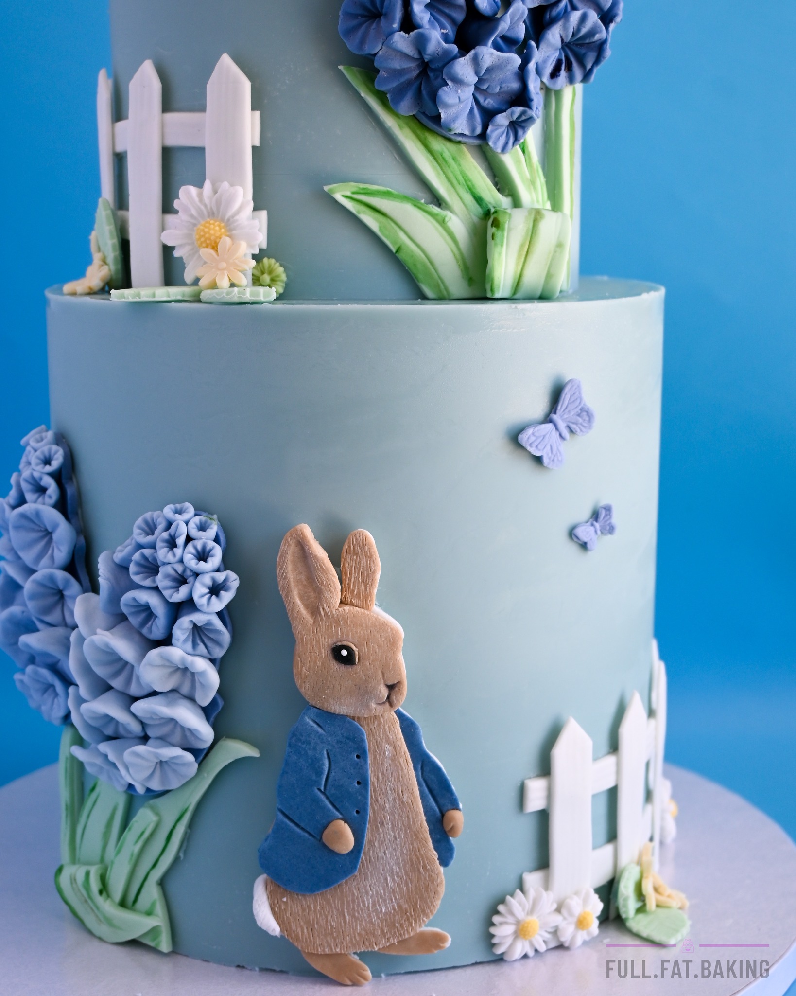 A soft garden-themed two-tier cake with blue flowers, butterflies, little fences, daisies and one very dapper bunny 💜
This one was so pretty and delicate, which of course means I spent most of the time hunched over tiny flowers questioning my posture, eyesight and general life choices.
All decorations handmade and edible.
Custom cakes available to order in Paphos.
#fullfatbaking #paphoscakes #cypruscakes #customcakescyprus #garden cake #floralcake #twotiercake #birthdaycakecyprus #sugarpastetoppers #edibletoppers #childrenscakes #bluecake #custombirthdaycake #paphosmums #cyprusmums
