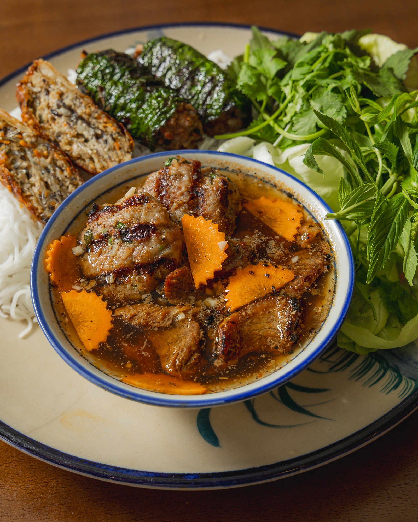 Meet Bun Cha, the taste of Hanoi.
Smoky chargrilled pork patties and caramelised pork belly swimming in a perfectly balanced sweet and savoury broth.
Pair that with fresh rice noodles, crisp pickled veggies, and a mountain of fresh herbs,