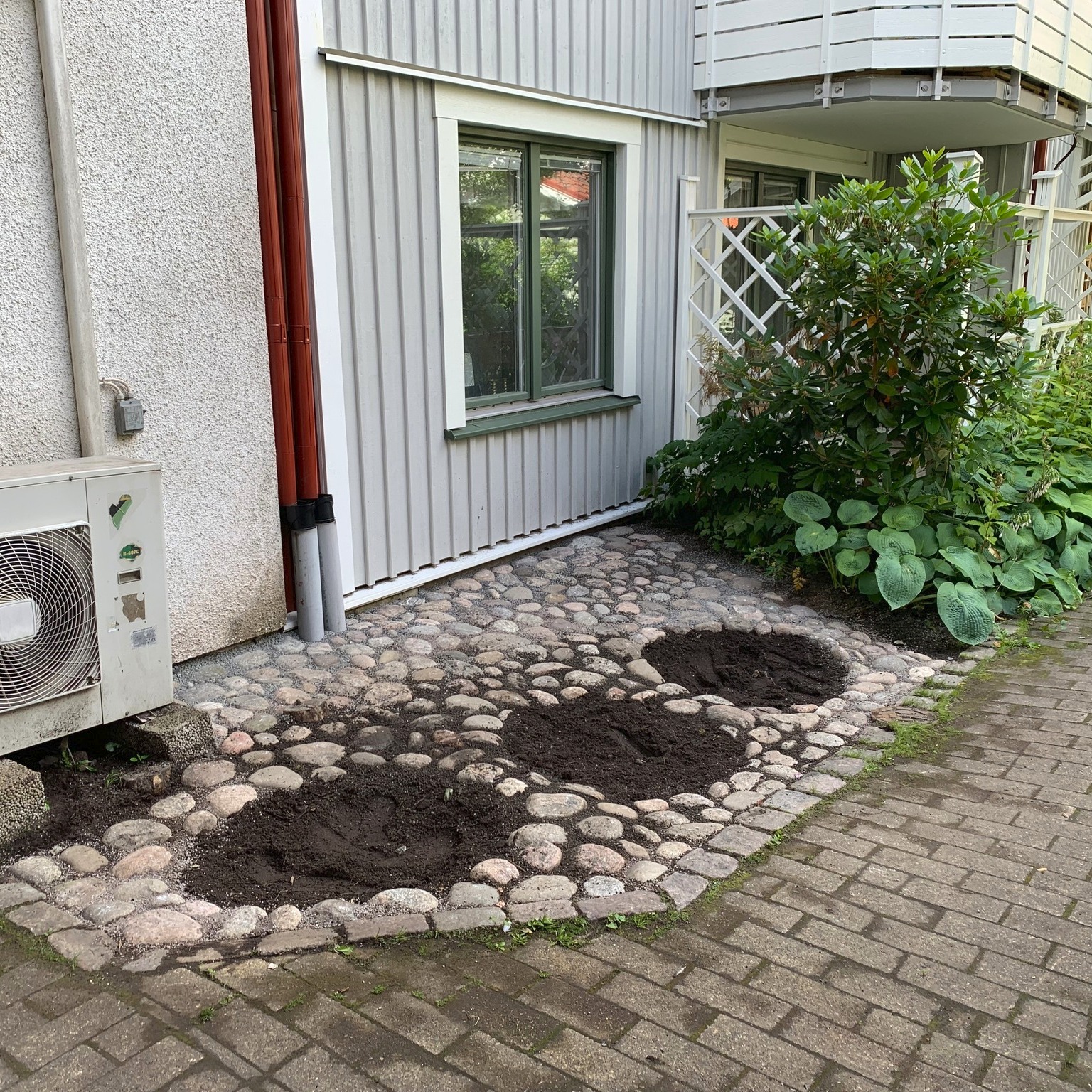 Här har vi grävt upp en mycket gammal stenläggning som genom åren sakta hade sjunkit ner i marken och hamnat ca 10 cm under jord. Brf:n önskade restaurera stenläggningen med samma sten fast i rätt nivå och med ett nytt lager stenflis för stabilitet. Ett roligt uppdrag tycker vi och det känns alltid bra när det går att använda platsens befintliga material! Vad ska vi plantera här tycker ni?