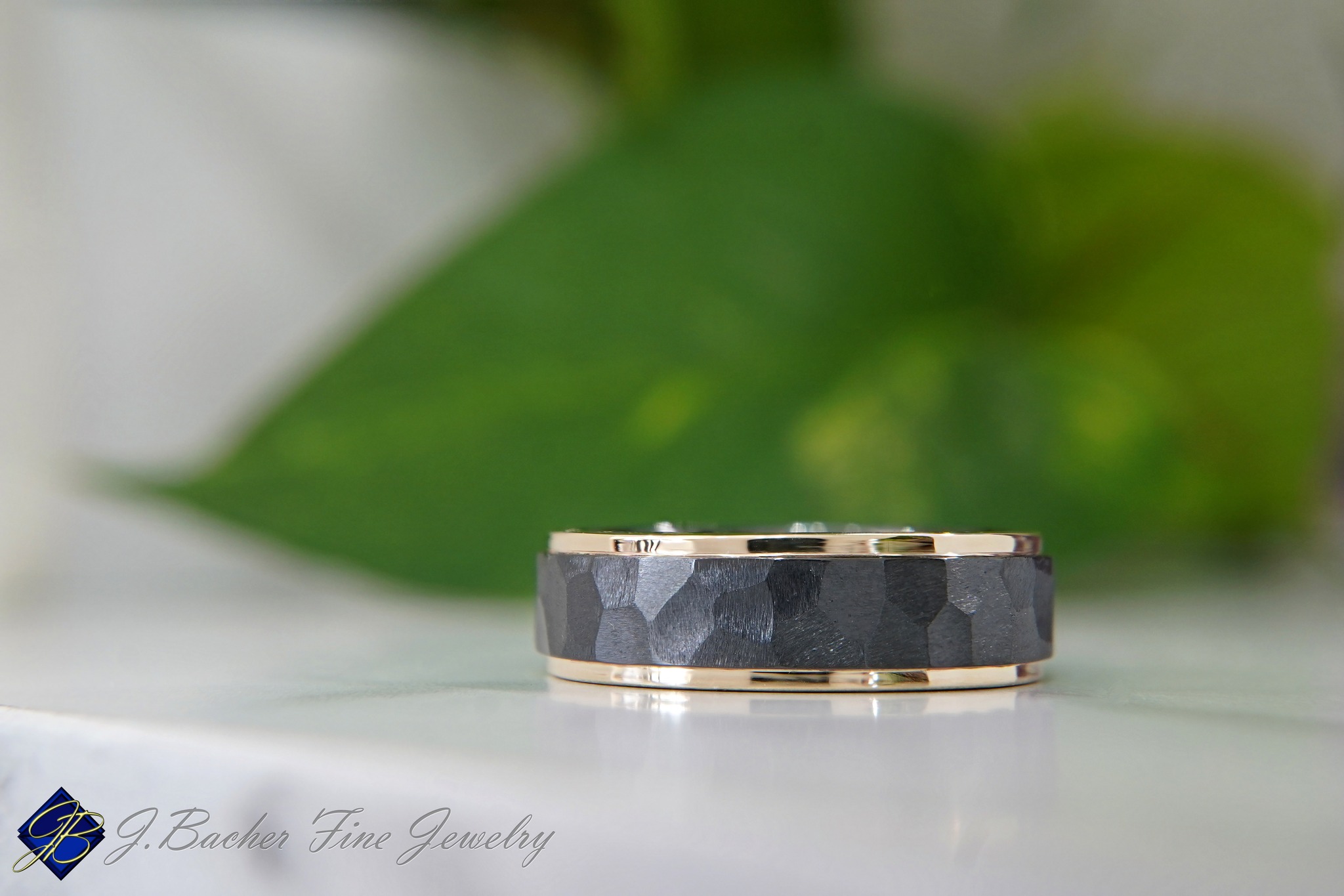 Congratulations to Billy & Gracie, who tied the knot in May!
Hers: Gracie selected a timeless yellow gold and diamond wedding band (not shown) to beautifully accent her engagement ring with its brilliant round center and scatter-style diamond shank.
His: A distinctive zirconium and yellow gold band with polished edges and a rugged rock-finish center.
Thank you both for trusting us to be a small part of such a special time in your lives.