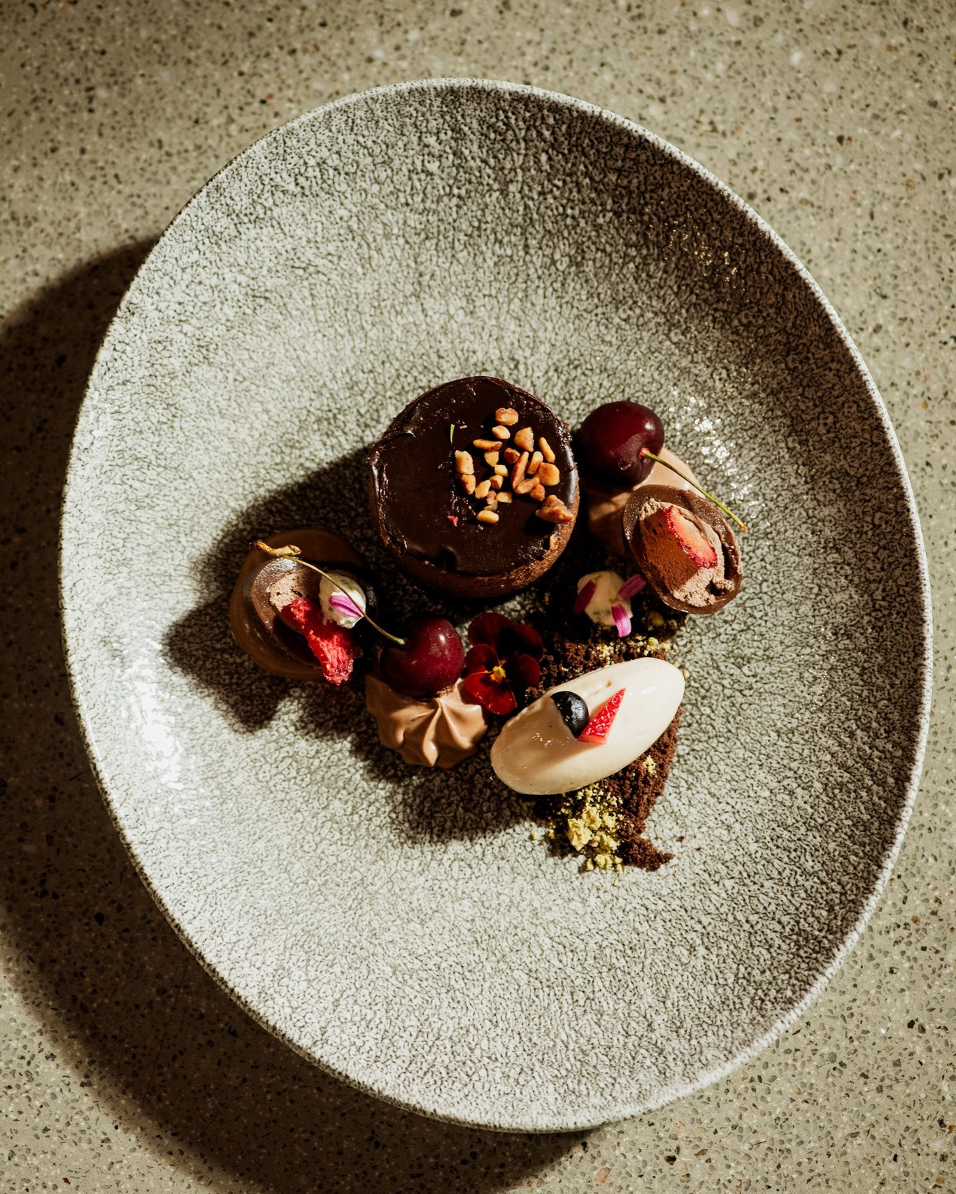 Rich Milk Chocolate Mud Pie paired with textured Black Forest Gravel, vibrant fresh Berries, and a scoop of velvety Vanilla Pod Ice Cream