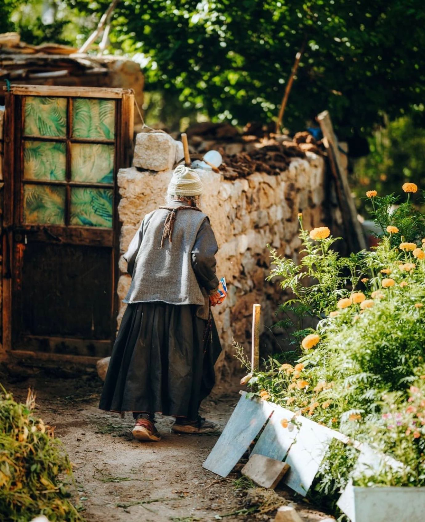 TRAVEL STORIES FROM LADAKH
.
.
"Riding towards Kargil we made a breakfast stop in a small village right on the highway. While some omelette and hot chai was being prepared I took out my camera and started scouting the area. In a small lane right next to our home restaurant i saw this beautiful lawn and the dadi, indulged in chanting and counting her way on beads.
She made my notice and i asked in sign language,
pointing the camera towards her, if i can take a
photo. To my luck, a smile and a nod was shared. The sun came out at a perfect time but i think it
quickly got too hot for her, so she changed places
and it just provided me more perspectives to play
with. What a morning it was”
.
.
Courtesy @dikshitmundra 
#ladakhbackpackers #travelholic #nubravalley #backpacking #reels #trendingreels #lehladakh #backpackers #trending ##wanderlust #spiritualawakening #instagram #nikonindiaphotography #ladakh #likeforlikes #backpackertrails #ladakhdiaries #followforfollow #adventurelover #himalyandiaries #himalayas #ladakh2022 #incredibleindia #shotoniphone #travelphotography#incredibleindia #follow4followback #instalike #instagood #instamood