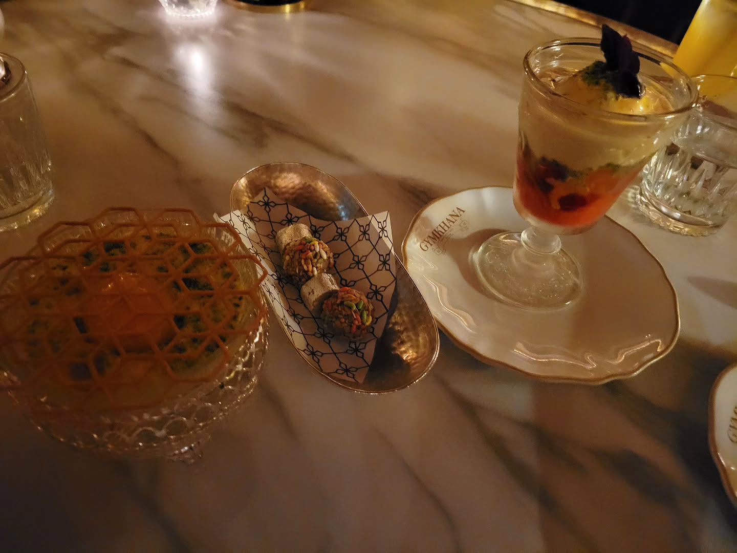 Cardamom & Basmati Rice Kheer (Left). Candied Fennel Chocolate Truffle & Kaju Katli Barfi (Center) & Saffron Pistachio Kulfi Falooda (Right)
@gymkhanalondon #michilinguide #michilinstar #michilinrestaurant #indianfood #gymkhana #tastingmenu #tastingmenufinalcourse #cardamon #ricekheer #truffle #chacolatetruffle #kajukatlibarfi #saffron #pisrachio #kulfifalooda #londoneats #internationalfood #london #uk #munchandmeandereurope #munchandmeander