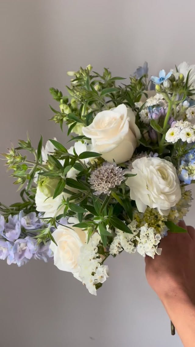 All pale blues and whites in early summer.
Why do we love it?
Local! Our grower friends grew these little hydrangea, white fluttery cosmos, frilly scabiosa, snapdragons, cute little yarrow, full and fluffy delphinium, and textural statice. Add in some perfect shades of roses and ranunculus, and we have ourselves a dreamy little bouquet.