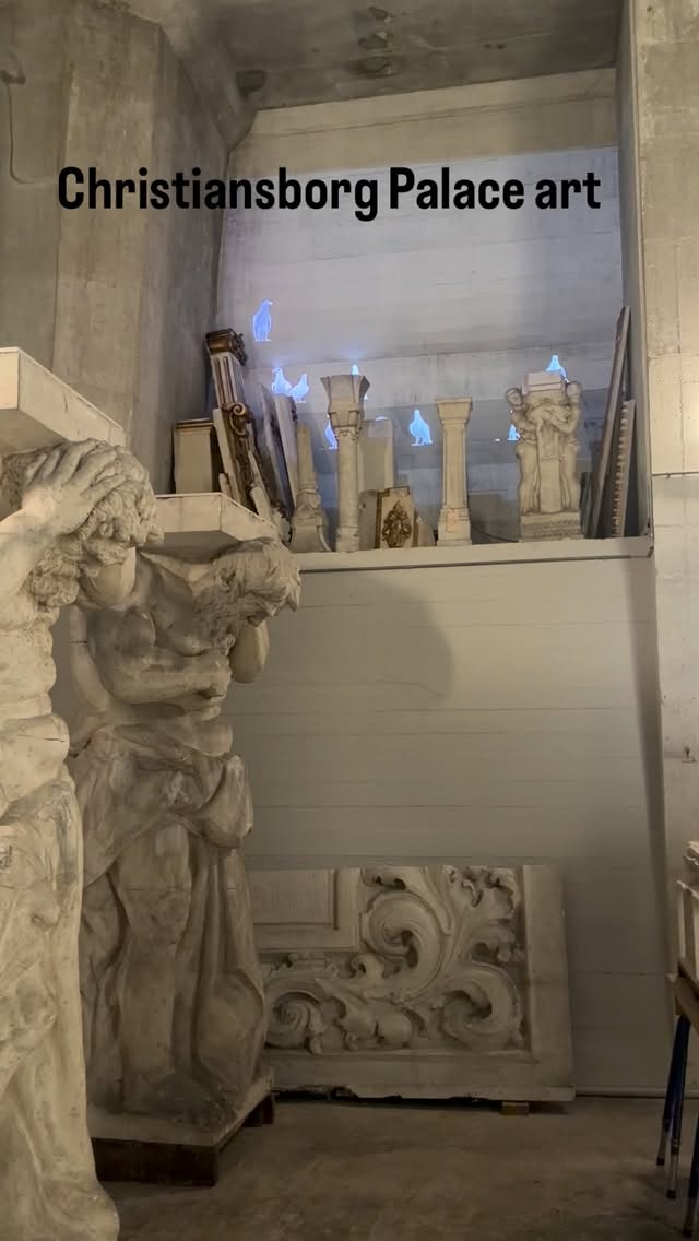 Some of the aged carvings on the Christiansborg Palace tower have been brought inside for restoration, and become an art instalation with the addition of projected pigeons.