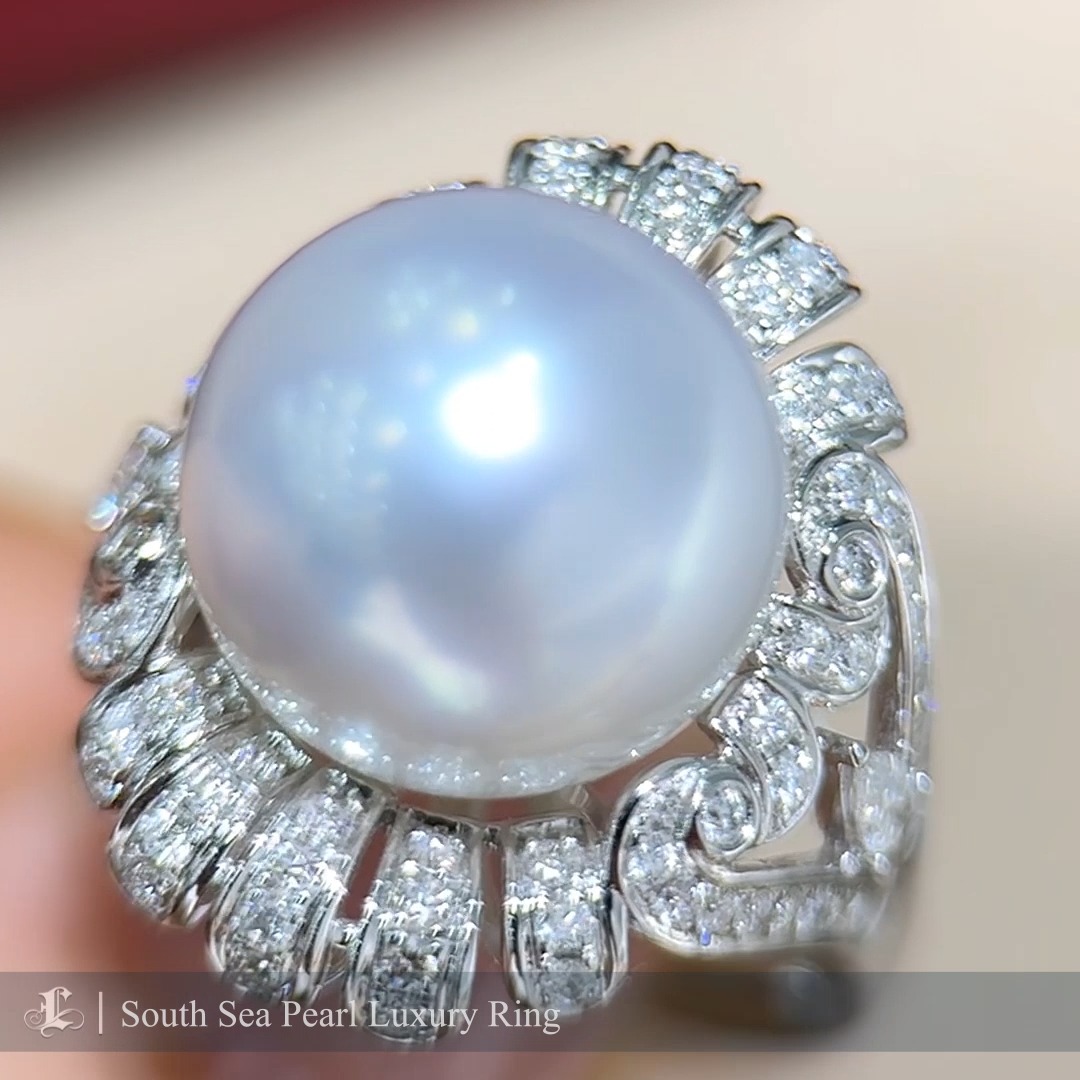 This breathtaking statement ring showcases a magnificent 13mm Aurora South Sea pearl, celebrated for its unparalleled size, silky luster, and natural beauty. Surrounding the pearl is an intricate design encrusted with 0.93 carats of high-quality natural diamonds, arranged to enhance the pearl's brilliance and create a luxurious, flowing motif. The diamonds' exceptional sparkle and the sophisticated craftsmanship make this ring a true masterpiece. Perfect for formal occasions or as an heirloom piece, this ring exudes timeless elegance and unparalleled sophistication, making it a must-have for fine jewelry connoisseurs.
#southseapearljewelry #southseapearlring