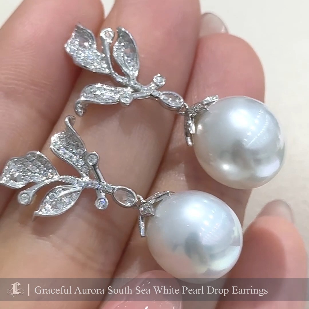 These elegant drop earrings feature slightly oval-shaped Aurora South Sea white pearls, celebrated for their silky luster and natural beauty. The pearls dangle gracefully from intricately crafted branches adorned with shimmering diamonds, creating a delicate and timeless design. These earrings exude sophistication and understated luxury, perfect for special occasions or as a refined addition to your everyday style. Handcrafted with precision, they are a stunning representation of elegance and natural artistry.
#southseapearlearrings #southseapearljewellery
