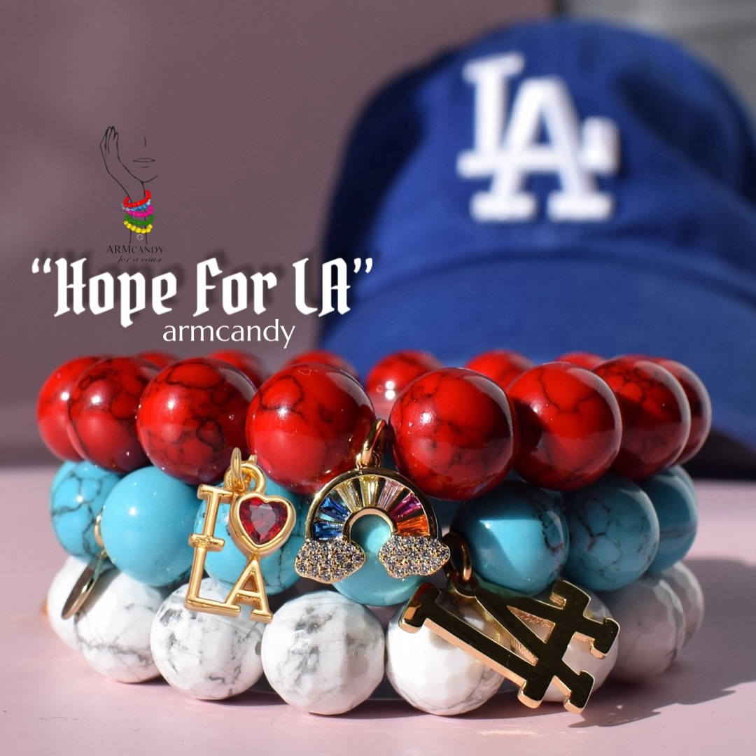 And we’re LIVE! The @armcandyforacause “Hope For LA” armcandy is now available and proceeds will be donated to the Palisades Fire victims verified GoFundMe pages. (Link In Bio)
When designing the Armcandy for a Cause bracelet to benefit those affected by the wildfires in California, Oriana chose the red howlite bead as a symbol of strength and resilience. Red, a powerful and passionate color, represents the unwavering courage of the communities affected by these devastating events. The fiery hue echoes both the intensity of the wildfires and the indomitable spirit of those who rise from the ashes to rebuild their lives.
The howlite stone, known for its calming properties, complements the boldness of red, signifying balance and hope amidst chaos. By pairing these elements, Oriana created a meaningful piece that embodies not only the struggles faced by these communities but also the strength and solidarity of those coming together to support them. Each bracelet is a reminder that even in the face of devastation, resilience shines through.
The bracelet is adorned with a Pavé Rainbow charm and an “I❤️LA” / California state charm. The rainbow symbolizes beauty and hope after the storm and serves as a reminder that even after the darkest moments, light and renewal can emerge. Grounding the design in purpose and serving as a heartfelt tribute to the affected region. The charms act as a reminder of the connection between the wearer and the resilient spirit of California’s people. Paired with howlite beads, known for their calming and grounding properties, the design represents both the perseverance needed to endure challenges and the promise of brighter days ahead while the bracelet becomes a symbol of balance and hope amidst chaos.
Through this thoughtful creation, Oriana crafted a meaningful piece that not only supports recovery efforts but also celebrates the strength, unity, and perseverance of the California community and gives hope to those affected by the wildfires. #HopeForLA #PrayForLa