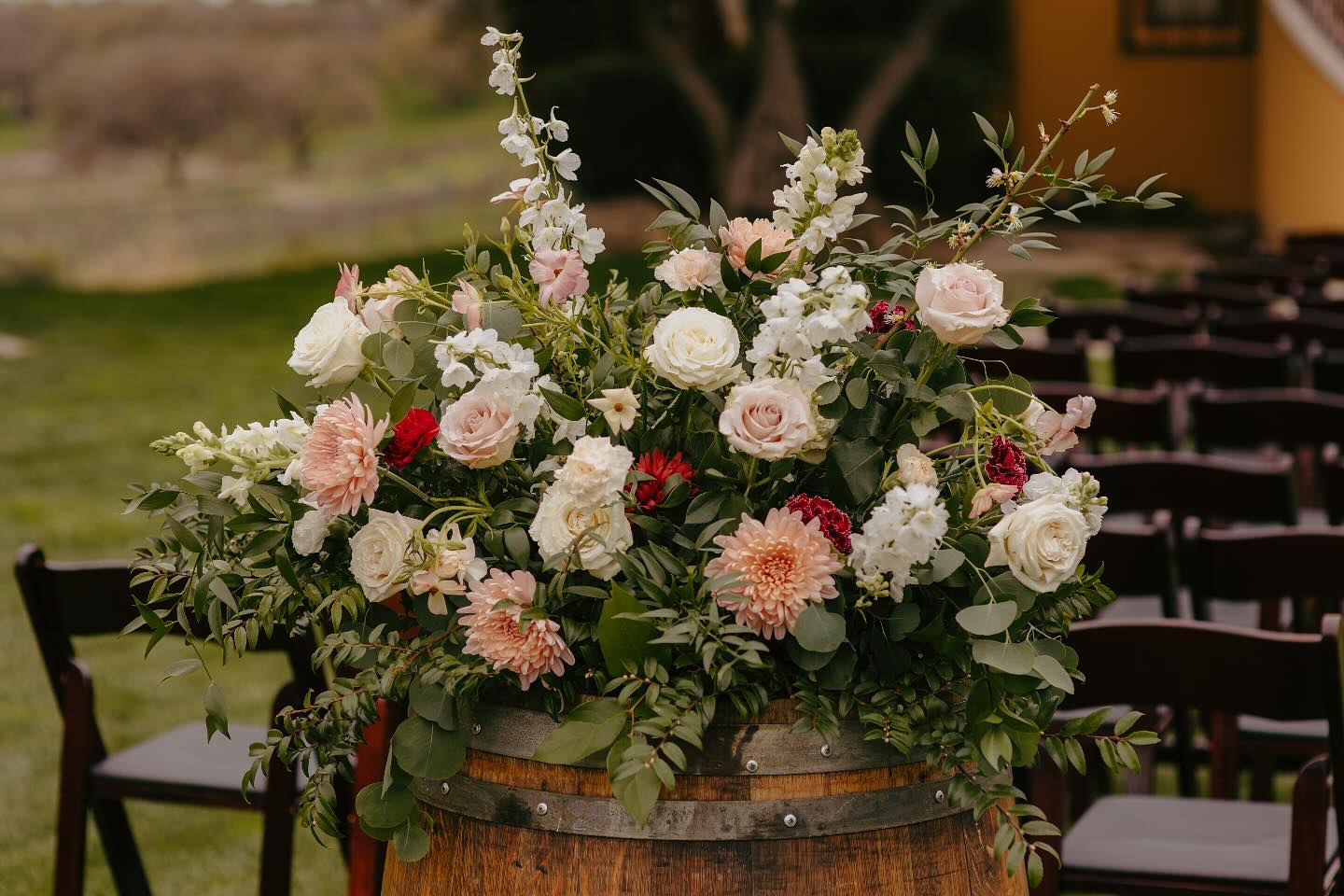 ✨Rustic charm meets bold blooms!✨ This stunning statement arrangement atop a barrel is the perfect blend of elegance and countryside romance!