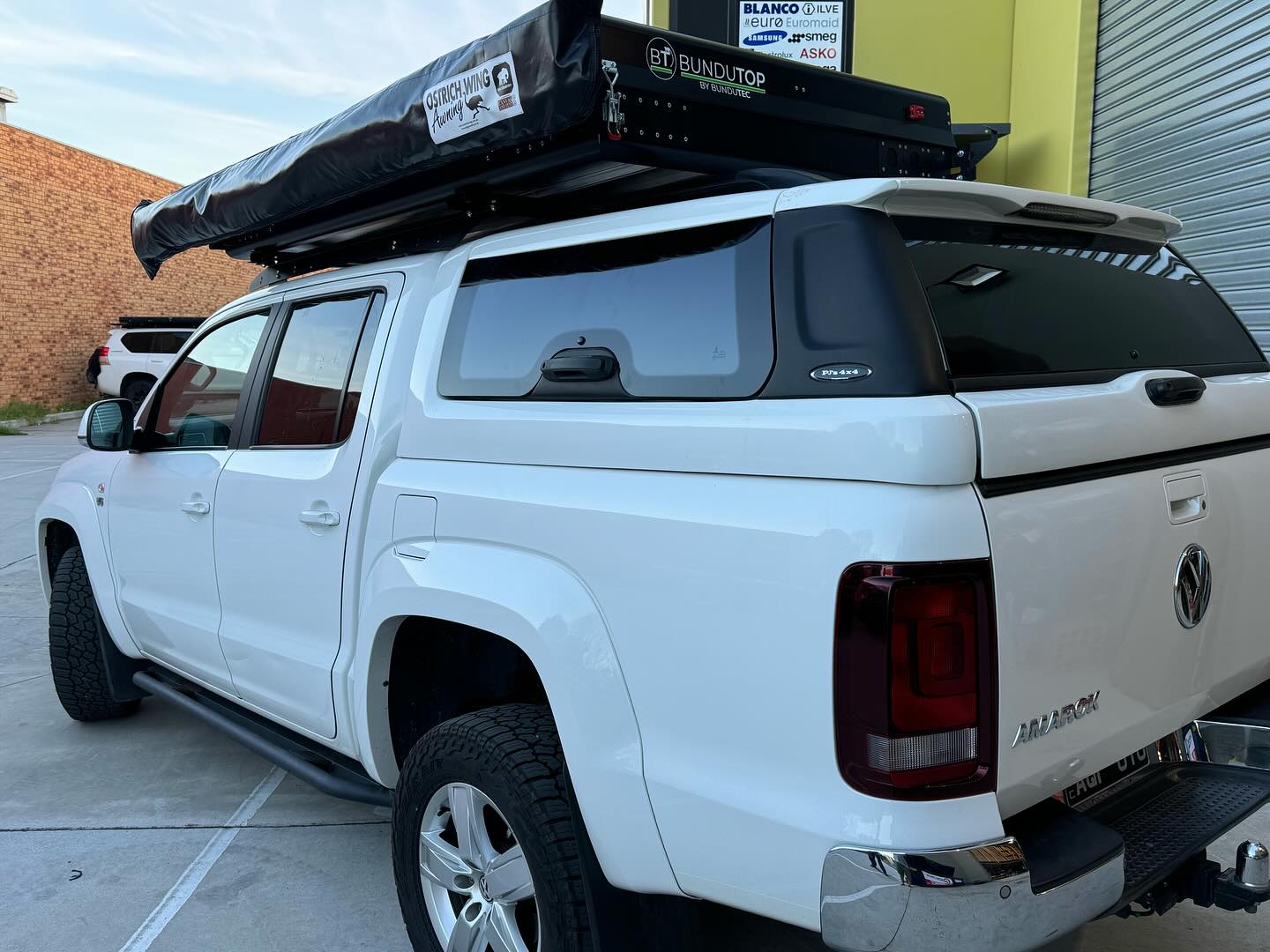 Amarok - bundutop and Ostrich wing mounted on a tough touring roof top tent rack