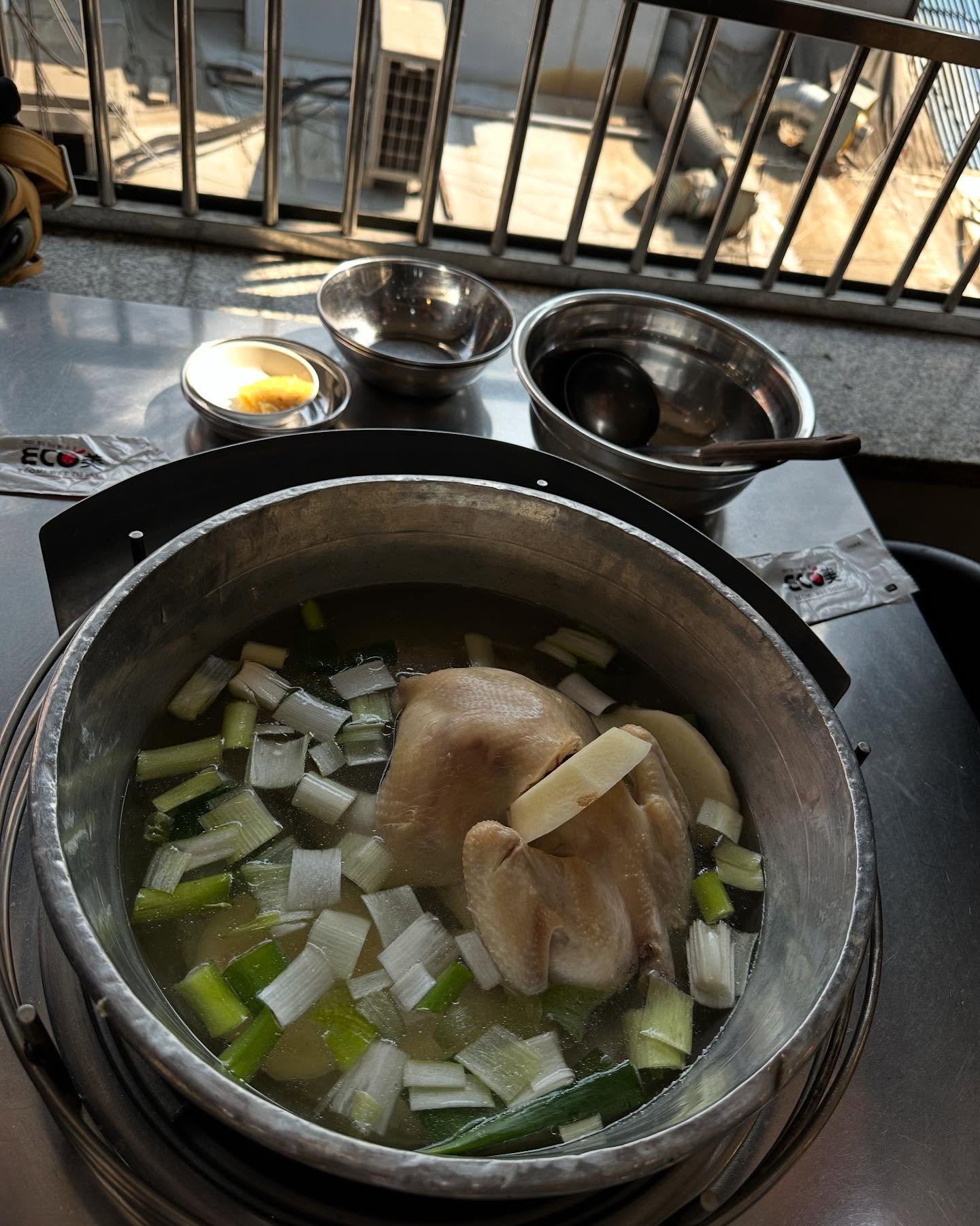 Giant hot pot of chicken soup with noodles and #tteokbokki for a late lunch in #Seoul? Yes, please. (Peep that bucket o’ #kimchi!) #scoffbanter #eatwelltraveloften