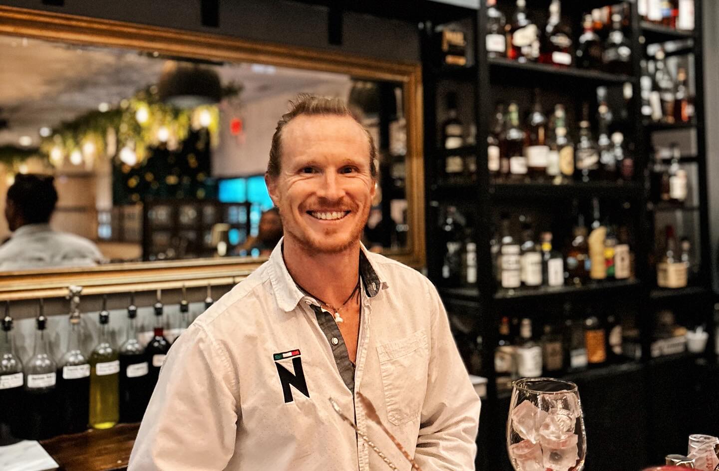Meet Dylan..he’s more than just a bartender—he’s the heart of the bar experience.
His passion for crafting exceptional cocktails is matched only by his love for great conversation. Guests are drawn to his easygoing nature, genuine curiosity, and the way he makes everyone feel like a regular.
Outside the bar, he’s an accomplished triathlete, Ironman, and Patagonman athlete, constantly pushing his limits and seeking the next big adventure. His energy, dedication, and adventurous spirit bring a unique and inspiring presence to our team and to every guest who sits at the bar.
Don’t worry if you don’t see him in June, he’s taking a small sabbatical trip to Europe to explore new cultures, trails, food and wine. He’ll be back in July filled with new ideas, experiences, and stories to share. Stop by to see him this month and wish him safe travels.
We are surprising him today with this custom plaque—Dylan’s Bar. Hope to have it hanging up at the Noto bar for many years.
Thank you Dylan for years of dedication and the positive vibe you bring to the company. Your presence contributes to the culture of this little restaurant which strengthens the Noto team. ❤️❤️❤️