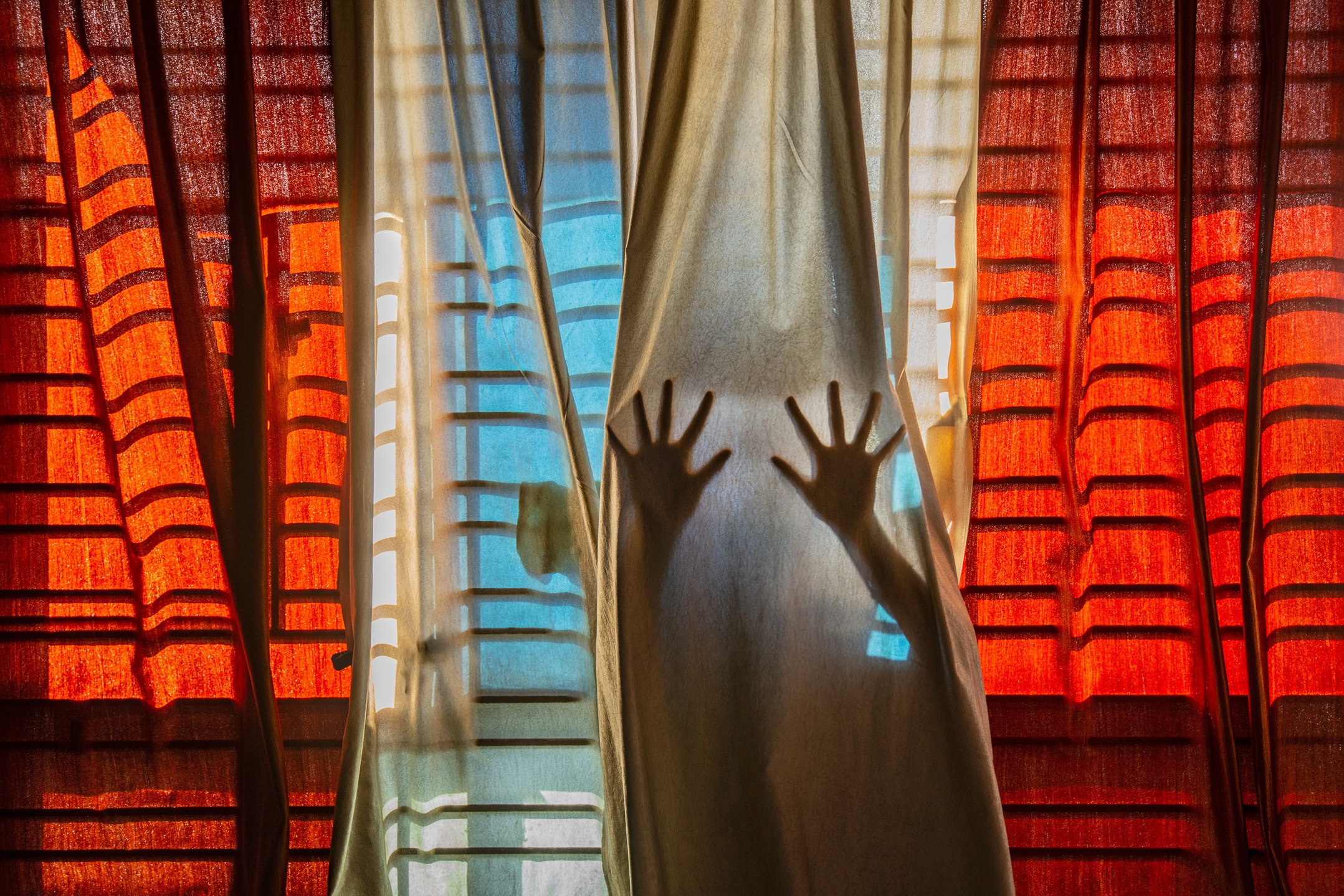No Escape from Reality, by Pubarun Basu (@pubarun.basu)
Among Pubarun’s many accolades, one of his most cherished achievements came during the global COVID lockdown.
He created a powerful, staged image of two hands trying to break through the feeling of entrapment.
"I created this picture with the idea of representing the feeling of being trapped in a moment, or one's own reality. I saw the curtains as a fabric of the space-time continuum, from which the two hands failed to break out. The shadow cast by the parallel railings onto the fabric also gives the impression of a cage, in which the entity is trapped for eternity"
This image resonated deeply with people everywhere. That's what led him to submit it to the Sony World Photography Awards.
"To my utter delight, it led me to become the first Indian to win the Youth award in the 14-year history of the competition.
My story, along with the photograph, of course, began to be featured in media outlets across India and the world. What made it even better was the numerous young people reaching out to me to discuss their budding area of passion."
📷Our interview with Pubarun, has more behind-the-scenes with his lens. Read it at the #linkinbio
#theimpactsociety #visualdocumentation #culturaldocumentation #storytelling #climatechange #culture #heritage #portraits #anthropology #photography #photographer