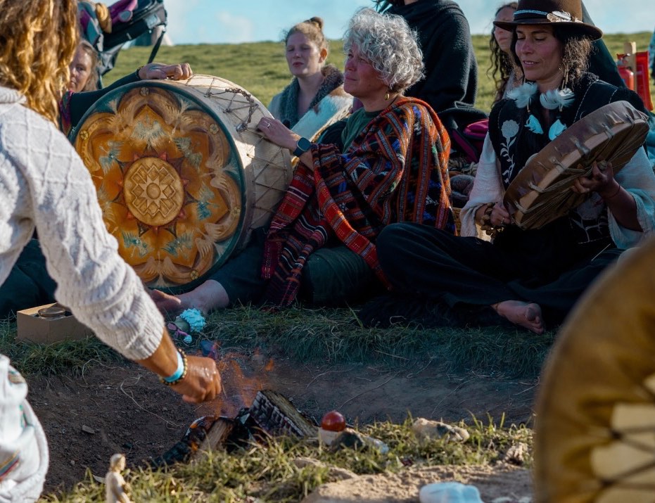 The Sacred Fire calls… Less than a week until it is lit and tended by our keepers, holding us through the length of our gathering✨🪶🌿
There’s a woman at the river
and she is called Fire Pit Singing
and she’s leaping through the jungle
and she roams the steamy forest
and her skin is hot and glistens
and she’s crouching by the water
and she’s digging in the coarse sand
and she gathers river pebbles
and she nests them in the fire pit
and she sets the small fire burning
and the flames are licking lightly
and she bakes the river pebbles
and she cracks the hot stones open
and she tastes the molten center
and she drinks the burning liquid
and it pours like tongues of Amber
and she swallowing the fire song
and she’s crouched above the fire pit
and the song is diving deeply
and it grows within her belly
and she curls up in the ashes
of the fire pit by the river.
There’s a big cat at the river
and she’s sliding through the jungle
and her muscles, tense and ripple
and her claws flick in the pale light
and her wild cat eyes are flashing
and she moves within a spring coiled
and she moves within a spring coiled
and she’s pausing at the sand hole
and she watches Fire Pit Singing
and she’s waiting by the ashes
and she waits within a spring coiled
and her wild cat eyes are flashing
and her wild cat eyes are flashing.
Fire Pit Woman now is rising
and she grasps the jungle body
and she’s whirling through the forest
and she growls and roars and rages
and her throat is opened darkly
and her voice is flying wildly
and she’s singing out the fire songs
and she sings within a vast fire
and she’s singing out the fire songs
and she’s birthed a mighty passion
and the cat is leaping with her
and she sings with Fire Pit Woman
and their bodies leap together
and they sing the heat of anger
and they saying the flames of great joy
and vasting about a fierce love
and they sing about a strong life
and the fire songs fill the jungle
and they spill beyond the forest
and they ride the stormy weather
and they move into the wide world
where they light the fires of many
where they light the fires of many.
~Fire Pit Singing by Carolyn Hillyer 🧡