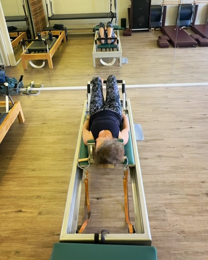 Another post op post. Scroll on unless you are interested in utilising comprehensive Pilates in your rehab with your clients.
Day 10 Post Op Knee Surgery: Back to the Reformer! Tell me what you think in the comments below!
Returning to the reformer post op is both exciting and daunting. Adding spring load can be dangerous to recovering muscles/joints and I would not recommend placing anyone a reformer this soon after surgery unless they are experienced.
Reasons I am ready to add spring load to my rehab:
✅ Clearance from my post surgery PT
✅ ROM in knee that exceeds what I would do on the reformer
✅ Ability to engage muscles sufficiently on PT exercises, pre-pilates, and intermediate mat
✅ No pain in knee and swelling managed.
Considerations in my first reformer workout:
✨This is surgery recovery of experienced practitioner, not first time use.
✨ ROM will be reduced
✨ Activation will be limited
✨ Muscles when worked concentrically and econcentrically to their full range will tire quickly.
‼️Remember, the Reformer is NOT a tool to build load like weight training, it is designed to help the body maintain connection through the full ROM of motion in both directions.‼️
Set up for first session
👁️🗨️ 2nd Gear, 2 springs. (An advanced setting, not basic, as minimal support from springs to allow minimal tension to knee joint)
👁️🗨️ Limited use of strap on Shortbox
👁️🗨️ No kneeling on knee just yet- no kneeling knee stretches
👁️🗨️ Hips down on pelvic lift to focus on engagement of seat and not overwork hamstrings on the lighter spring setting
‼️THESE SETTINGS ARE FOR REHAB PURPOSES, NOT FOR BODY NEW TO PILATES OR TOO WEAK TO USE A REFORMER.‼️
This first session was really amazing and really exhausting. My main focus was maintaining connection in my muscles, especially when returning the springs and not compensating in my strong side. After the session my body feels more connected, more aligned, and more space in my knee after the rehab yesterday. I was able to stay connected in my left leg throughout the workout. #swanseapilates #rehabpilates #reformerpilates #ukpilates #kneerehab #meniscusrehab