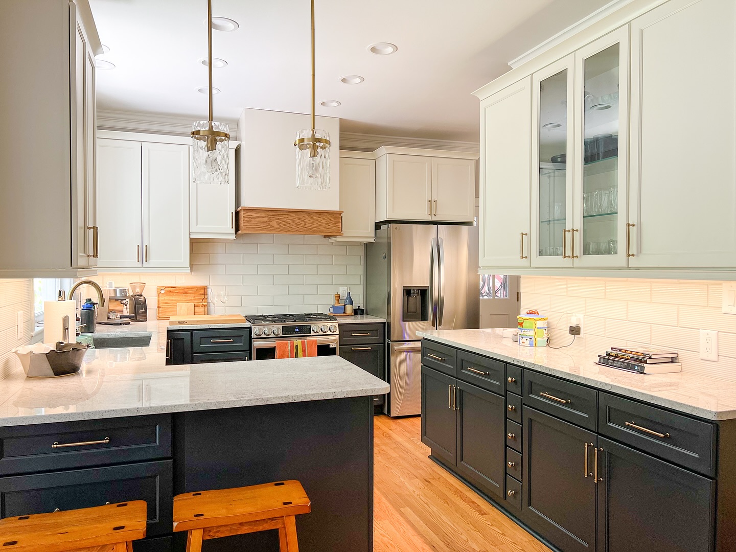 This client came to us wanting to find a good compromise between function and beauty (a common theme between married couples!)
We needed to maximize as much countertop space that we could while still maintaining or increasing as much storage as possible.
In the end, we took out a storage closet and converted it to a beverage center and a tidy drop zone coming in from the garage, removed an unused desk area and replaced it with a large pantry with pull out drawers, and maximized the use of a shallow wall of drawers and doors.
By lightening the cabinets, counters, and backsplash, the whole room felt twice as big but still homey.
Overall, our clients were happy and that makes us really happy!