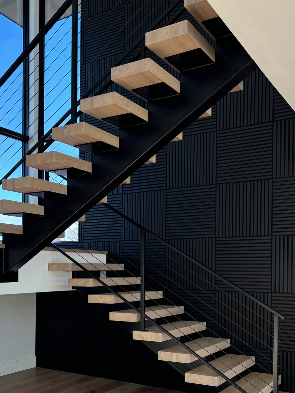 Entry With White Oak Floating Stair Against a Backdrop of Acoustic Slat Wall from WVH..I designed the grid pattern to mimic existing architectural details. Shout out to @vineyardcustomhomes for making my vision come to life! I like design details that offer sculptural interest and functionality:)MM
#customhomes #eagleidaho #boiseinteriordesign #stairdesign #woodveneerhub