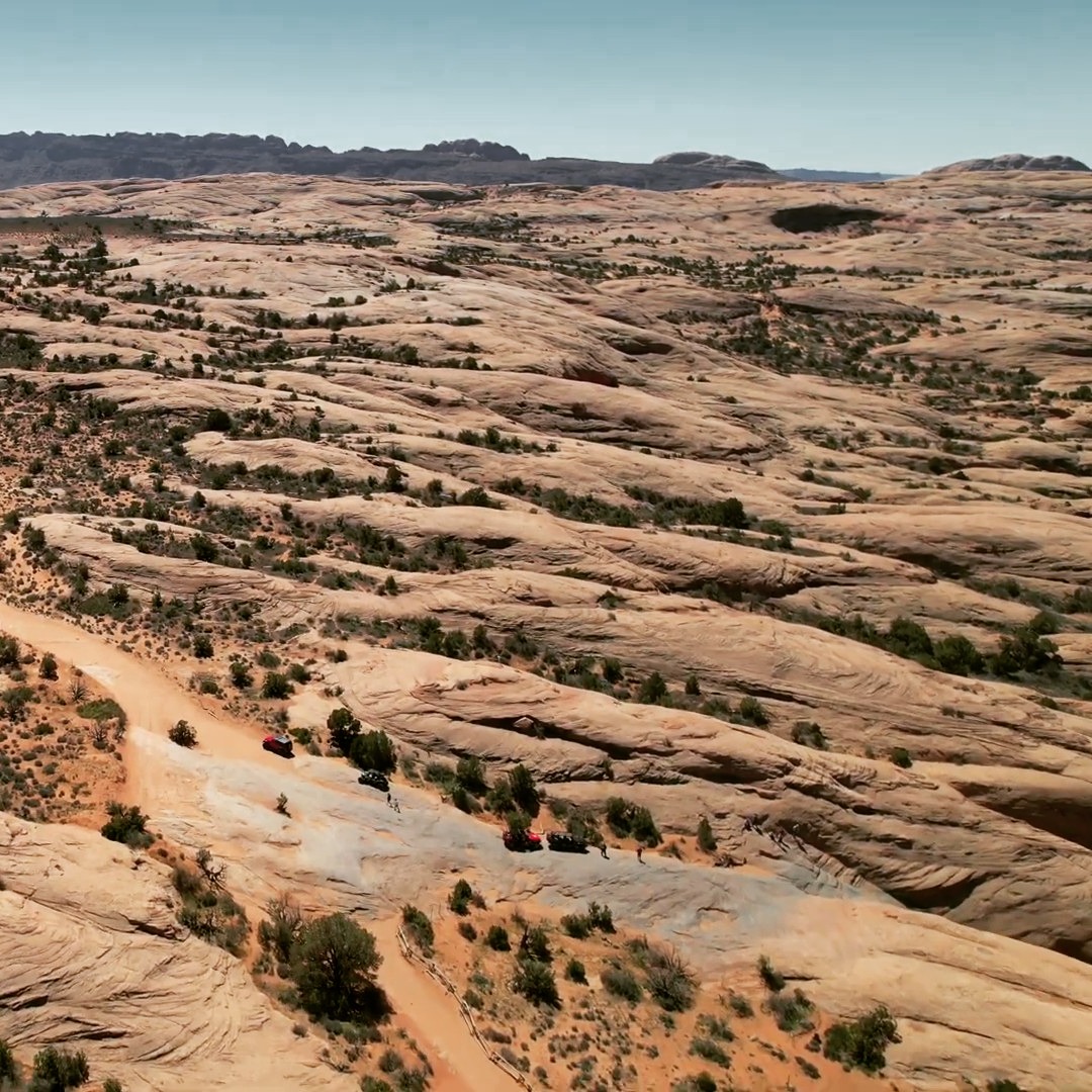 We rolled out of Moab just after sunrise on Day 5 of the Utah BDR, rigs packed and ready for another stretch of trail. A few blocks east of town, the pavement gave way to sandstone at the entrance to Sand Flats Recreation Area — and from there, we climbed straight onto Hell’s Revenge.
It’s one of those trails that doesn’t need an introduction. The first fin rises up immediately, smooth and steep, and before you know it, you’re driving over ancient dunes turned to stone. The traction is unreal — rubber gripping rock where you wouldn’t think it could.
We didn’t take the extreme lines this time — no Hell’s Gate or Escalator — just a clean run through the main trail. Even so, it was everything Moab is known for: steep climbs, tight descents, and views that stretch across the Colorado River to the La Sals.
The exit turned out to be longer and tougher than we expected, but that’s part of it. Moab has a way of keeping you honest.