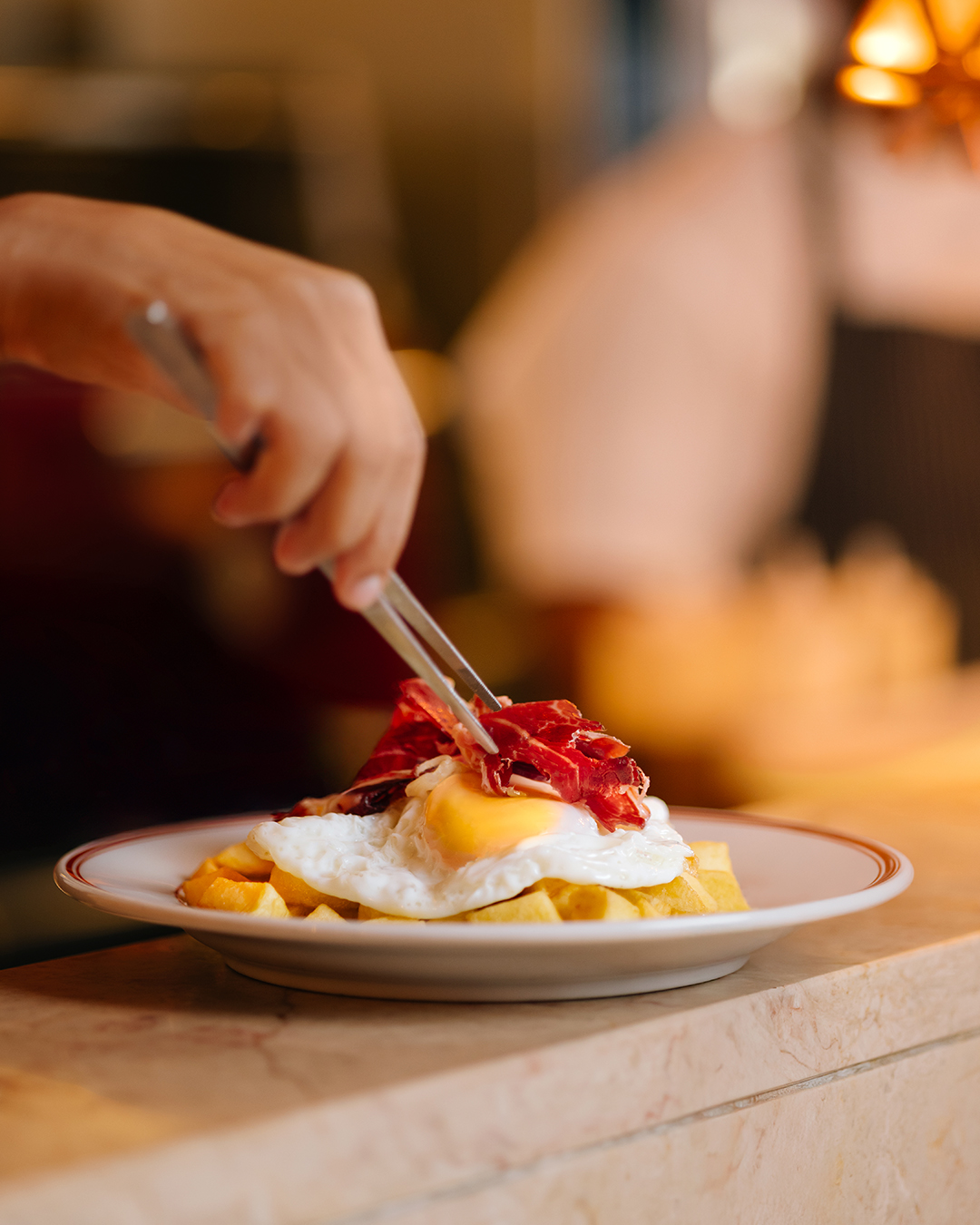 O toque final que muda tudo. Huevos Rotos con Paletilla Ibérica, sofrito de cebola e pimento vermelho. Um prato com história e sotaque espanhóis.
--
The finishing touch that changes everything. Huevos Rotos, fried eggs with potatoes, Iberian paletilla, onion sofrito, bell pepper. A dish with Spanish history and accent.