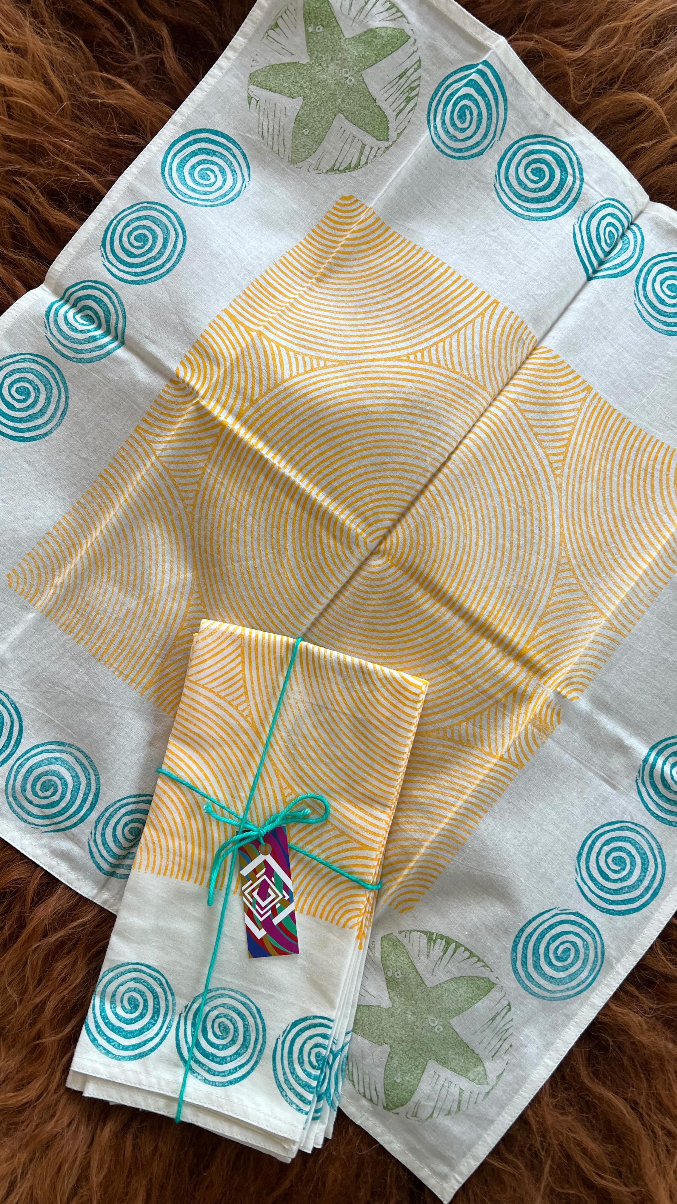 Another day, and more beautiful artisan textiles across your feed! Today I’m sharing napkin sets. Made from organic cotton these are soft-to-the-touch, and with each wash the texture becomes more buttery.
Recently, Ive been experimenting with multicolor sets (peep the chevron pattern) and am loving the bright colors all together.
All are block printed using hand carved wooden and lino blocks. This current inventory is about half my own carvings, and half I’ve sourced from India. Did you know that at one point England tried to outlaw Indian blockprinted textiles? The colors and patterns were so vibrant the government worried that their own textile manufacturing would be outshined. (And it was!) Despite laws passing, the fabrics remained very popular and the attempt to ban them was unsuccessful.
The histories of fabrics and colonialism are deeply entwined, which is part of why craft is always political! We are not separate from our supply chains. Shopping at local small businesses offers the opportunity for transparency, and empowers you in making decisions about what systems you are supporting.
