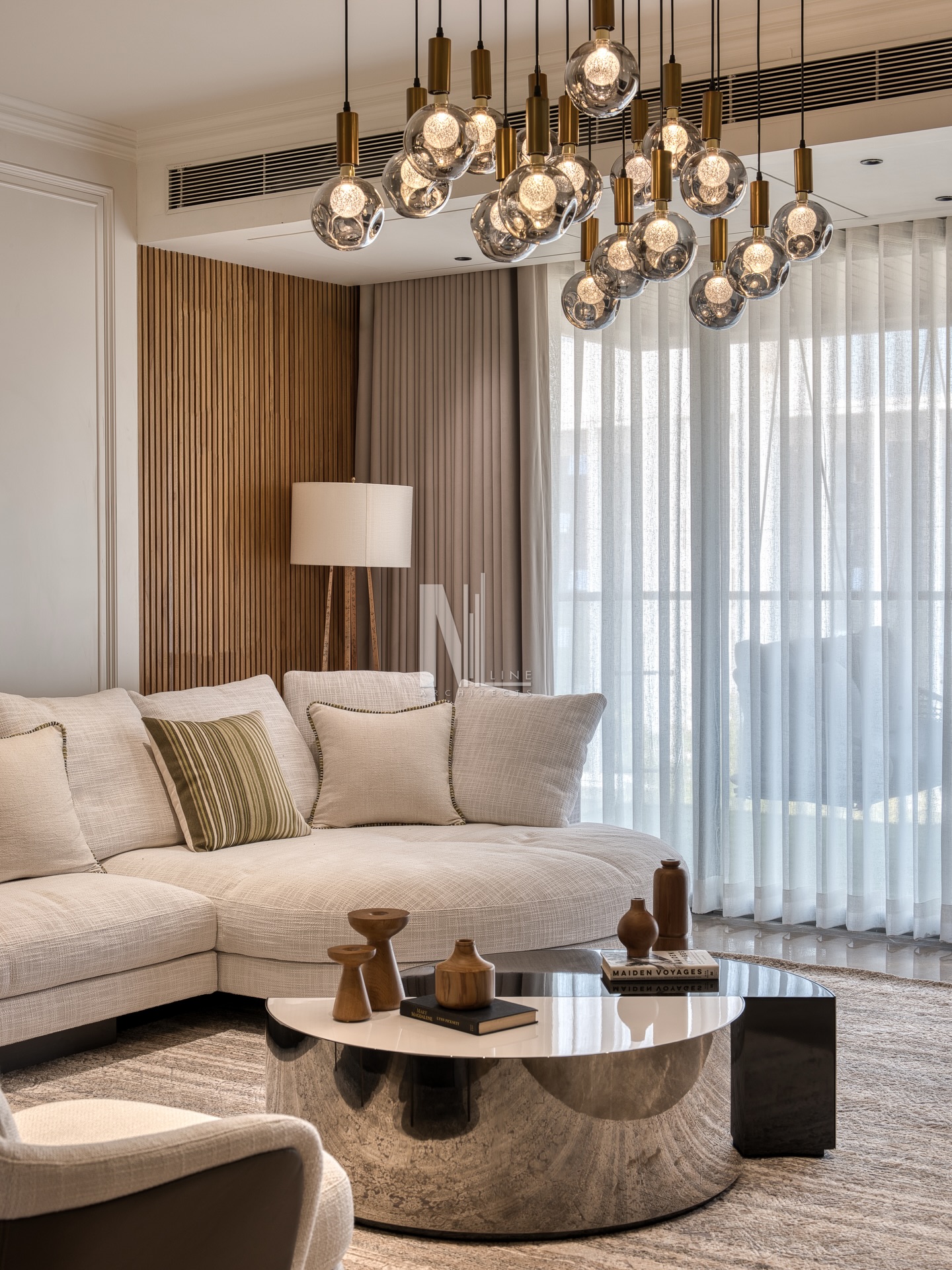 Where daylight meets design.
This informal lounge brings together a plush sectional, soft neutrals, fluted wall detailing, and a statement chandelier, creating a perfect balance of comfort and sophistication.
A reflective center table anchors the setup, adding depth and a touch of modern elegance.