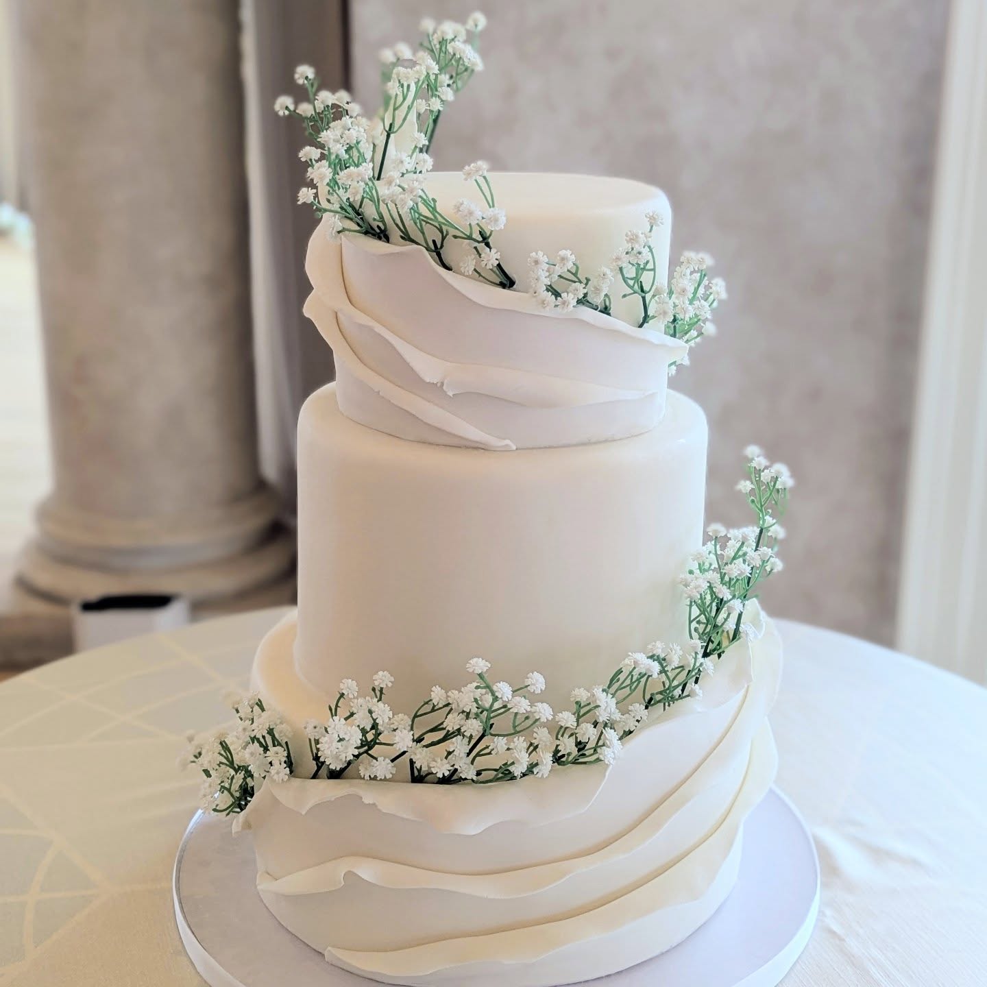 ❄️A moment for the beauty of simplicity and movement 🤍
This all-white fondant wedding cake features delicate swirling fondant panel ruffles and cascading baby’s breath for a timeless, romantic finish. Effortlessly elegant. Forever classic. ✨ Congrats to B & R! 💒
✨WOW what a busy birthday for me! 😅 A wedding cake and a Christmas market all on the same day! But truly a FULL heart💖, thank you to each and everyone of you for always coming out to see me and showing me your constant support! This year has to not been easy with my rotator cuff surgery and recovery. But I feel so very blessed! Thank you so so very much. 💕🙏🔥💯
Wishing everyone an AMAZING holiday season!!!🎄☃️❄️
#TheCakeBee #RomanticWeddingCake #ClassicBride #WhiteAesthetic #ElegantAndSimple #WeddingDetails #RusticElegant #FineArtWeddings #WeddingCakesOfInstagram #weddingcake #LuxuryWedding #VirginiaWeddingVendor #ThePerfectSlice