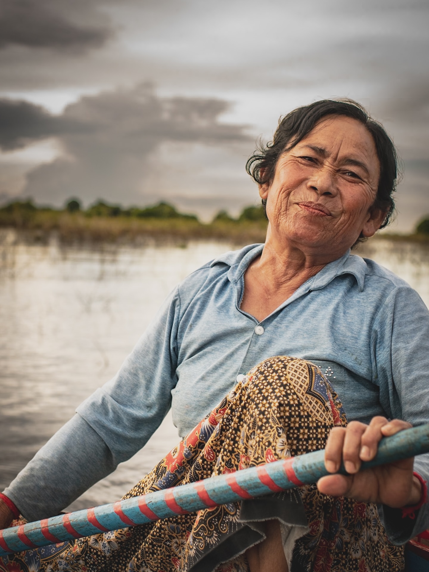 Tonle sap lake in the northern part of Cambodia is the largest fresh water natural reservoir in Southeast Asia. Rowing was a traditional occupation for the men in the village that is built on the lake but after Covid hit they left the village desperately looking for income. While they were away women took a role of the boat driver and that’s how it stayed until today. Women drive tourists around the mangrove forest for 6 months of the year when the level of water is high enough to get through by the boat.
However that time frame shrinks as water level decreases year by year. Climate change is one reason another endless dams built by Chinese companies in China and Laos on Mekong river.
Limiting the water inflow they let this lake to become more and more just a tourist attraction rather than a suitable inhabitant. There is a number of villages on the lake with communities for generations relying on water resources and seasonal changes.
With this entire burden, somehow these rowing women still find joy in their daily routine. The one next to me wore beautiful makeup, felt grateful even for the little money she made, and you could tell it would take more than a change in the current to break her.
#photographystories #womenphotographers #climatechangeawareness