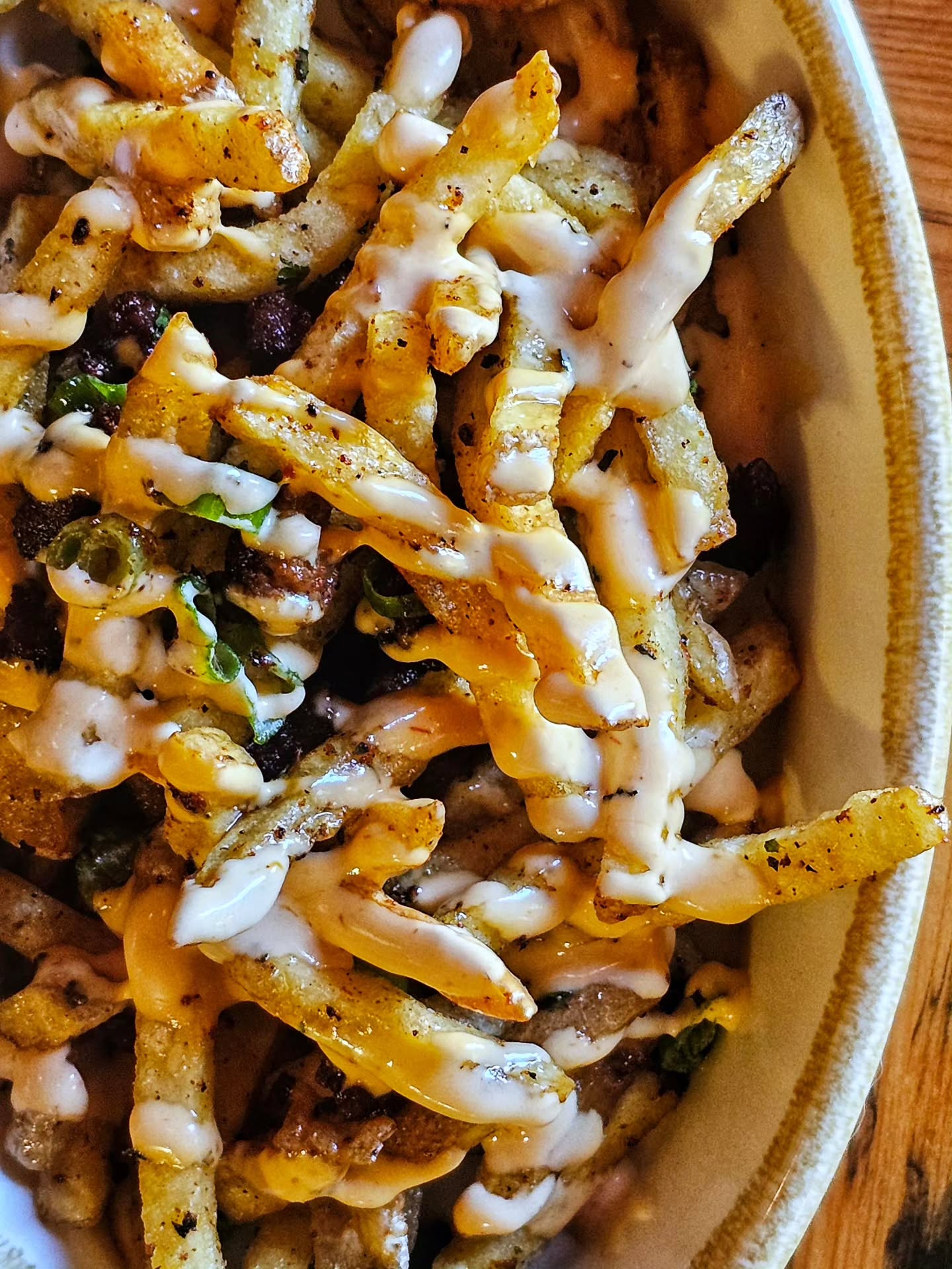 SALCHIPAPAS | house-fries, Peruvian sausage, aji amarillo sauce, slivered green onions