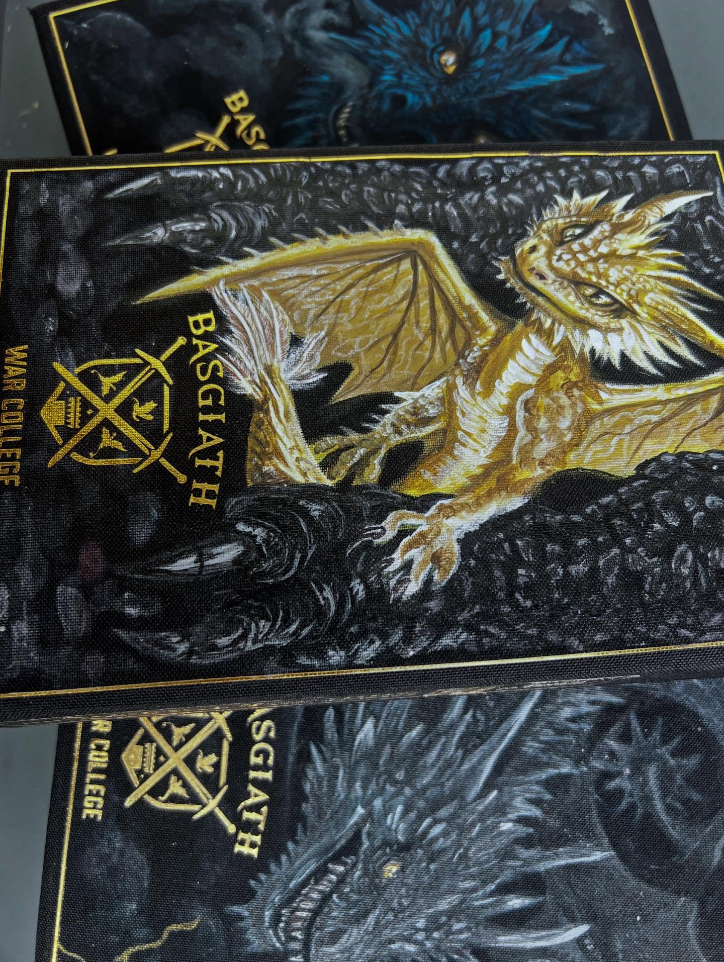 Last post about the series and composition as a whole 🖤🐉
I wanted this rebinding to treat the Fourth Wing series as a single, continuous arc rather than three standalone books with choices and design made to be flexible for the books not yet written or published.
Across all three fore-edge paintings, Violet is kept at the same scale and placements. This anchors her physically and visually as the constant point of reference while her circumstances, skills, and threats evolve. What changes isn’t her size, but her position in the world around her.
Each edge captures a different phase of her training and transformation as a dragon rider: early survival, loss of control, and full-scale confrontation. Dragons grow larger in frame, compositions become more unstable, and the environment shifts from structured stone to open sky to total collapse… mirroring the escalation of the story itself.
The bindings are unified through shared materials and structure: Basgiath-style textbook spines, consistent dragon-scale motifs, repeated insignias, storm-toned endpapers, and gold detailing used sparingly to mark moments of power, loyalty, and choice.
Dragon portraits on the covers serve as sentinels for each volume, reinforcing the bond between rider and dragon that defines the series.
Together, the set is meant to feel studied, issued, and lived with. Not only a decorative object, but war-college artifact documenting Violet Sorrengail’s journey through survival, discipline, and command.
Can’t wait to come back to these in the future 🤘🏻 Book 1 was my favorite and I haven’t enjoyed the last two as much, but I’m hopeful about where the series could go and the little book nerd who reawoke when this was first published.