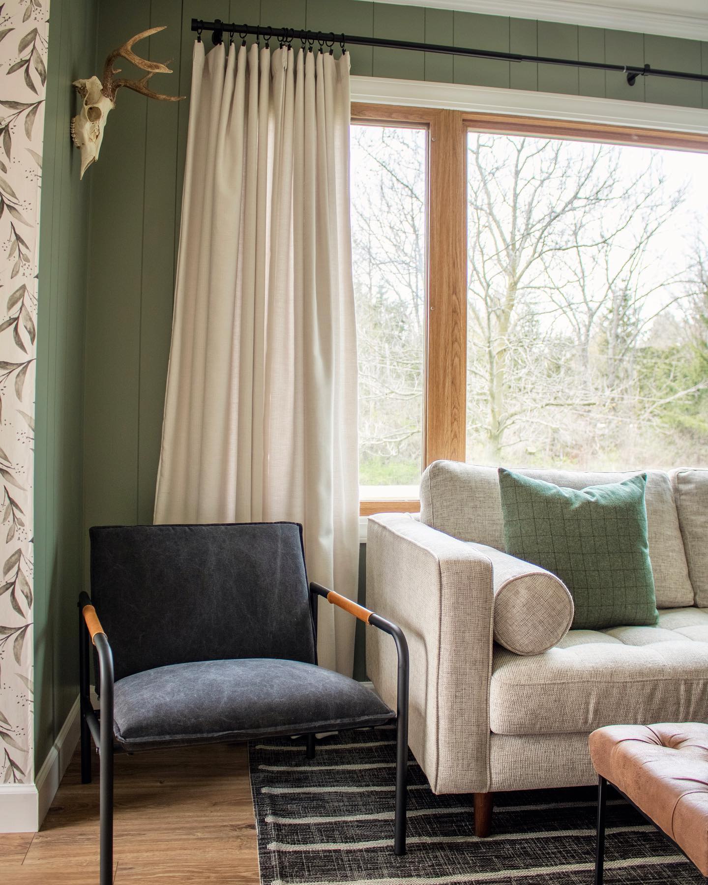 Happy May 🌼 I’m just over here living my homebody life 🌿🧺 .
.
.
#jessiesinteriors #interiordesign #interiordesigner #loveyourhome #howyouhome #interiorstyling #targetstylehome #amazonhome #article #articlefurniture #svensectional #arearugs #europeanmount #deerskull #greenpaint #paintedpaneling #potterybarn #potterybarncurtains #interiorphotography #prettyinteriors #homesweethome #livingroom #livingroomdecor #livingroomstyling #joannagaines #magnoliahome #magnoliahomewallpaper #wallpaper #floralwallpaper