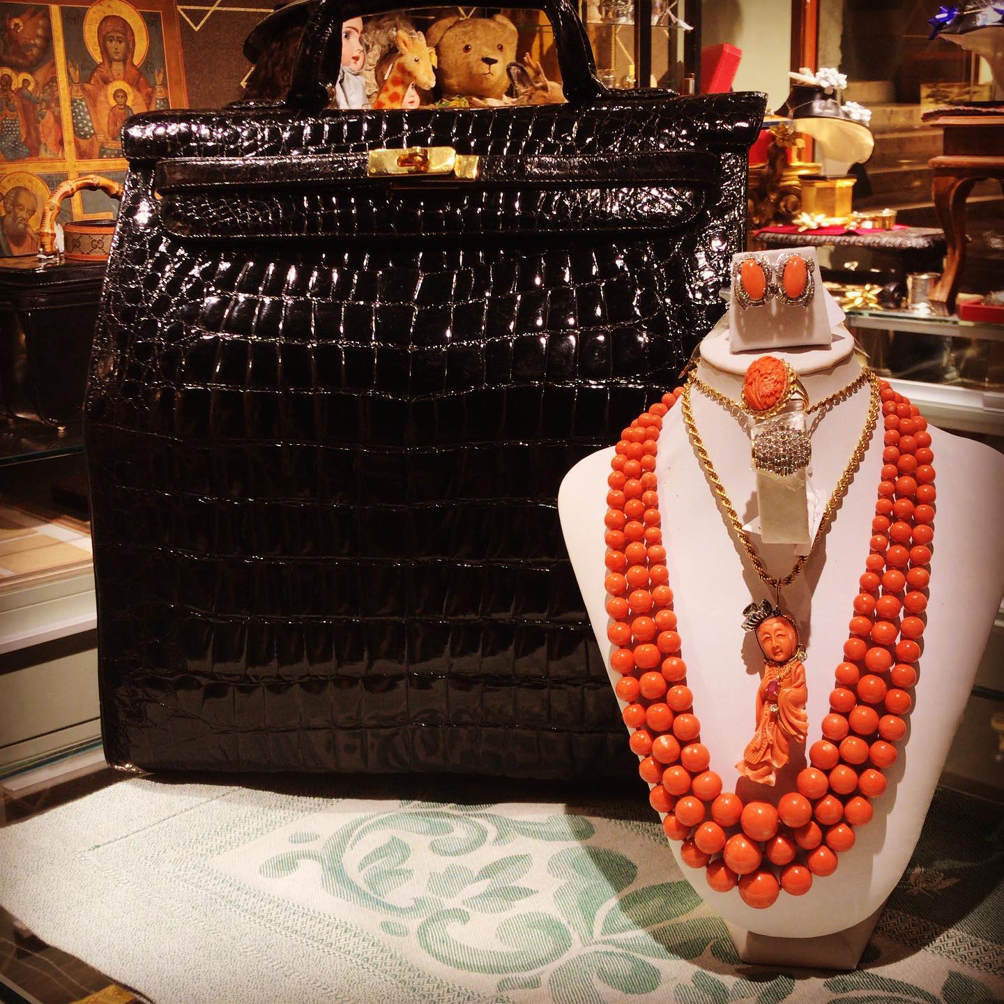 Anticoponteantiquariato. Collana, pendente orecchìni in corallo. Sullo sfondo valigia in coccodrillo pon pon nera.Visita il mio sito anticoponteantiquariato.com. Link in bio#corallo#coralnecklace#crocodileskin#antiques#venice#rialtobridge#