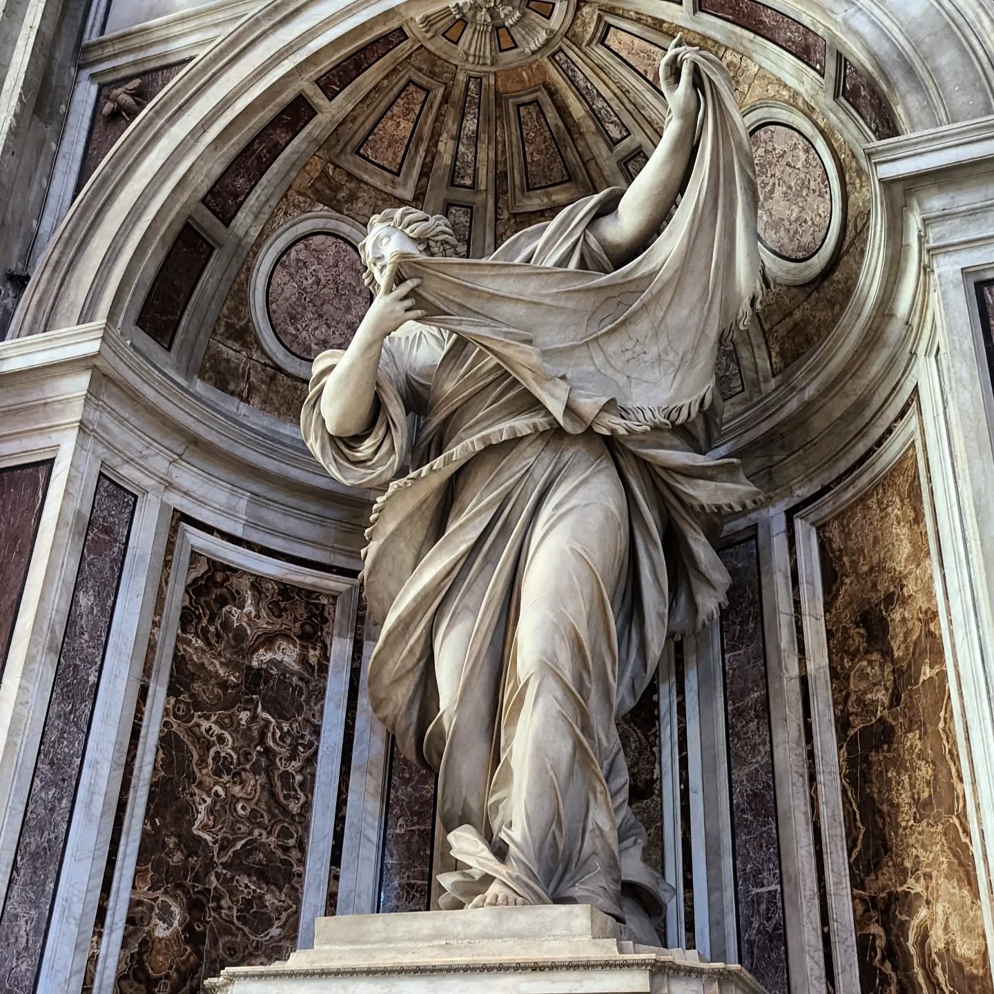 The statue of St. Veronica, holding the veil she used to wipe the face of Christ, visible in the marble. This work sits at the base of one of the huge piers that support the dome of St. Peters, and marks the space where the relic itself is displayed annually. #latinrocks #stpetersbasilica #baroque