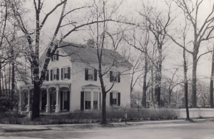 Across the street from Captain Whittemore at the intersection of North Village and Maine Avenues, in what was called “the Grove” in RVC due to all the large chestnut trees, another Maine-born mariner, Captain John W. Gallison (1824–1897) built this Victorian residence in 1870. At the time, it was the northern terminus of Village Ave with just woods to the north. The property had a large daisy field in the rear, numerous crab apples and over 50 towering oak trees. In 1882, the home and land were purchased for $300 by the Corbett family and family members continued to live in the home until the mid 1940s.
Captain Tristram Thurlow Corbett (1846–1908), was born in Cutler, Maine, to Captain Daniel and Abigail Corbett. Tristram—like Whittemore and RVC’s other sea captains—began his seafaring life as a young teenager, following in his father’s footsteps.
At just 26 years old, he assumed command of the Lena Thurlow after his father died from injuries sustained in a hurricane-related sailing accident near the Bahamas. Corbett’s first wife, Jeannette, often traveled with him and made one poignant request: if she were ever to die at sea, she wished to be buried back home in Maine. Tragically, while sailing with Tristram near Cuba, she succumbed to a tropical illness at the age of 26. Lacking a coffin, the crew transported her body in a cask of rum, and she was laid to rest in Old Cutler Cemetery in Maine.
In 1876, Corbett married Clara Lavinia Willeby. Together they had three children—Willeby, Olive, and Eugenie—and the entire family continued the seafaring life. Remarkably, Eugenie was born aboard one of her father’s vessels, the Olive Thurlow. The three children continued to live their adult lives in RVC with Olive remaining in the N. Village Ave house until it was sold to Elizabeth Murphy and demolished in 1947. She then moved to 79 Riverside Dr. and Williby to 94 Grand Ave.
After the house and its barn were demolished in March 1945, the Mayfair Co-op building was constructed in 1950 and still occupies the site.