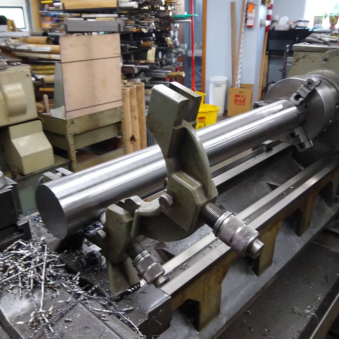 Using our custom built mobile electric hoist to get these 200lb bars into the lathe for facing, drilling, and tapping the ends.