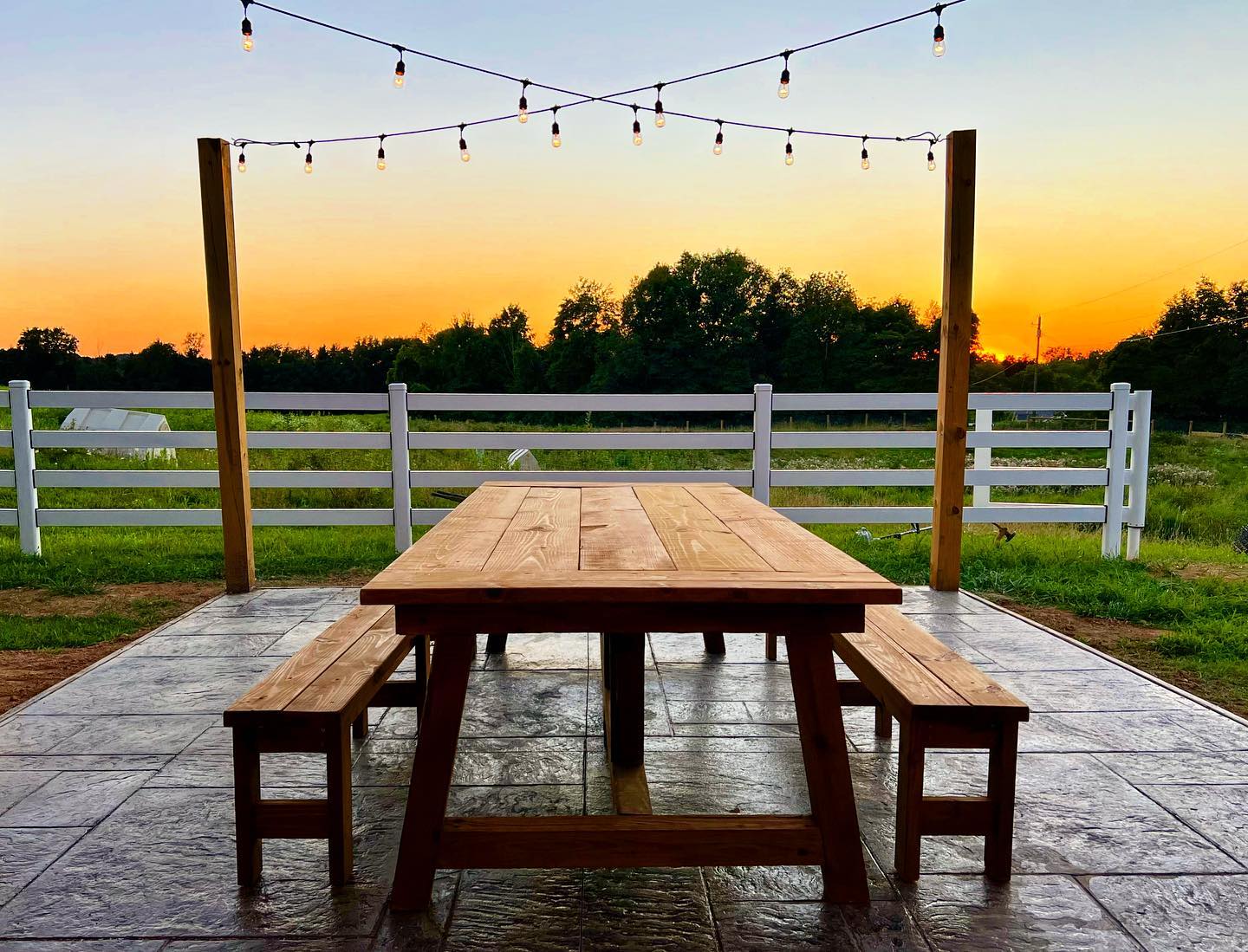 This beautiful farmhouse table was built by our very own Brandon @embreeswoodwork 🤩 Underneath the party lights, it’s the perfect spot to enjoy the sunset over the pastures of grazing sheep & goats 🐑🐐