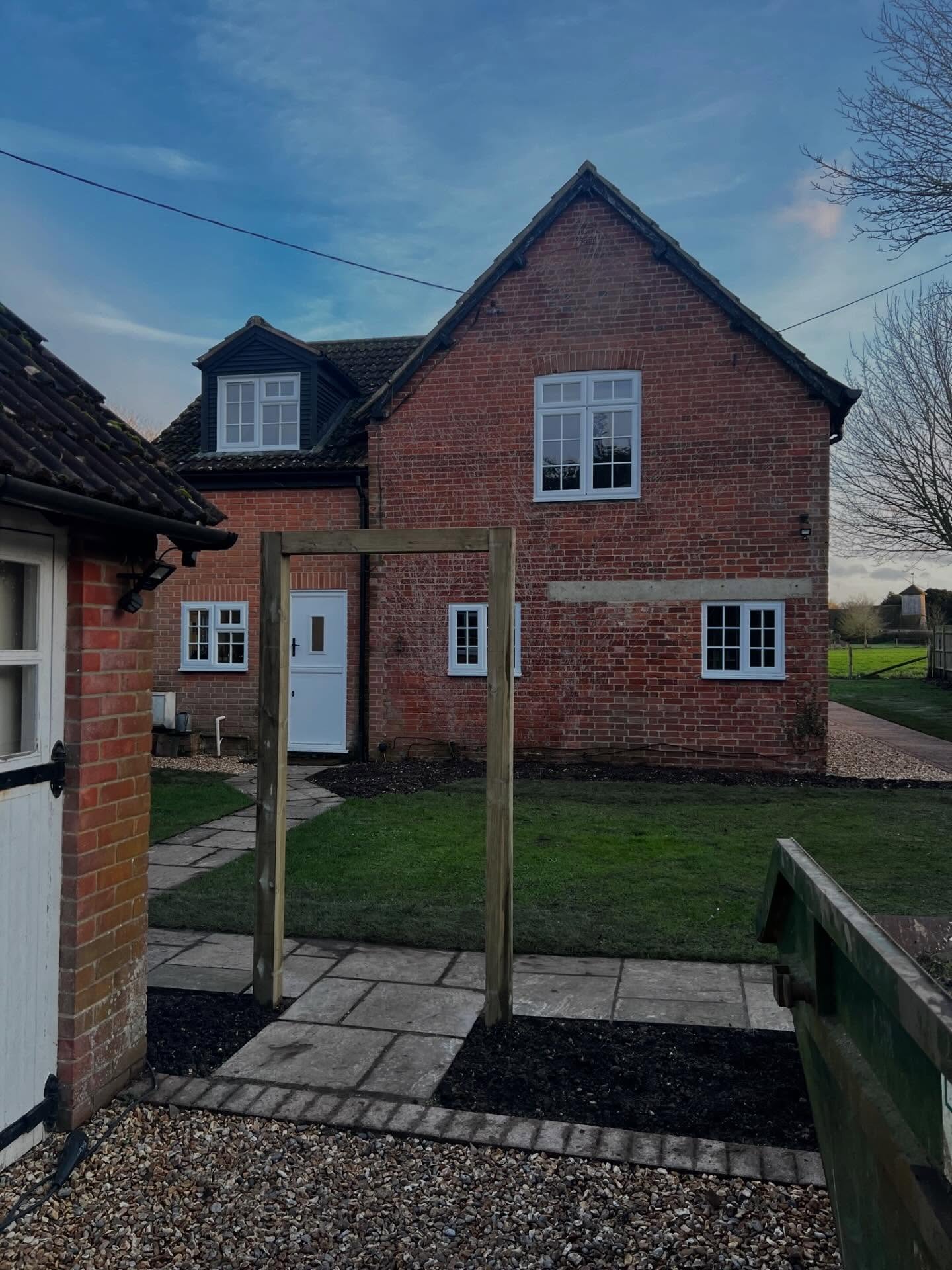 🍏 Little update on a pretty Hampshire garden with beautiful views across the fields. Hard landscaping is complete and the client will carry out the planting in stages. The front garden will be screened by an evergreen hedge and the arch identifies the main entrance. There is a traditional clay paver path down the side of the house and a new seating area has provided the perfect spot to enjoy the views. A simple, low cost solution with a big impact on the layout and flow of the garden. #gardendesign #simplegardensolutions #gardendesigner #ruralgardens #simplegardendesignideas