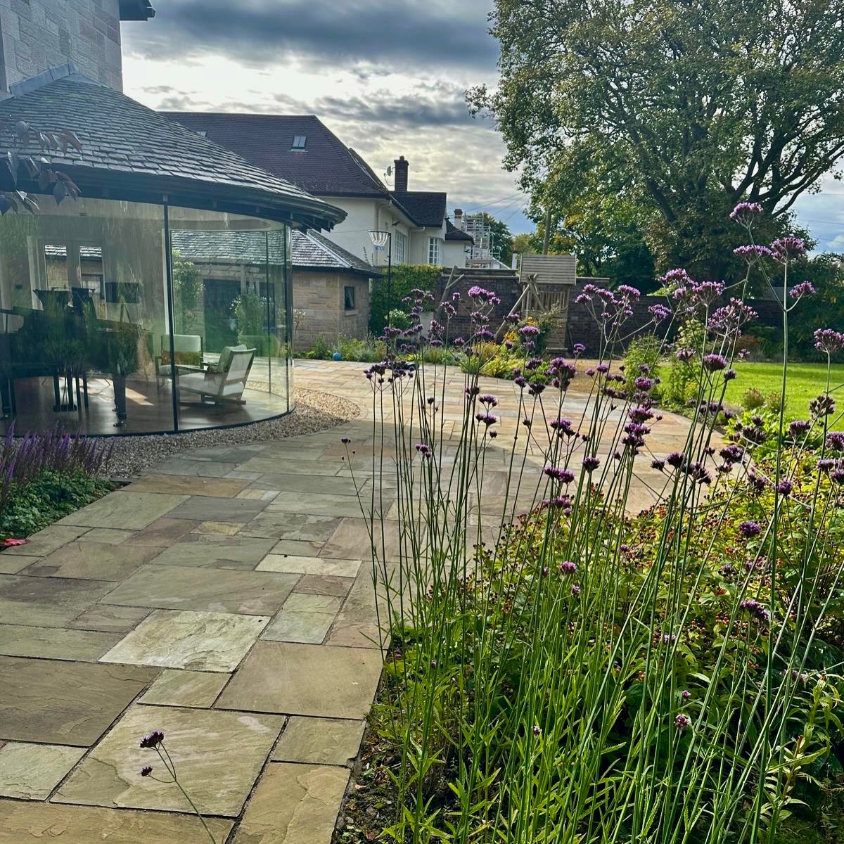 Great garden design doesn’t compete with its surroundings — it works with them.
In this space, the sandstone paving follows the natural curves of the building, softening the architecture while enhancing its character. The flowing lines create movement, guide how the garden is used, and naturally connect the home to the landscape beyond.
🌿 Sympathetic design respects the setting
🪨 Natural materials complement the building
🌱 Soft landscaping adds warmth, balance, and seasonal interest
By blending structure with planting, this garden captures both beautiful detail and everyday functionality — a space that feels considered, comfortable, and timeless for family living.
Thoughtful design is what transforms an outdoor space into something that truly belongs.