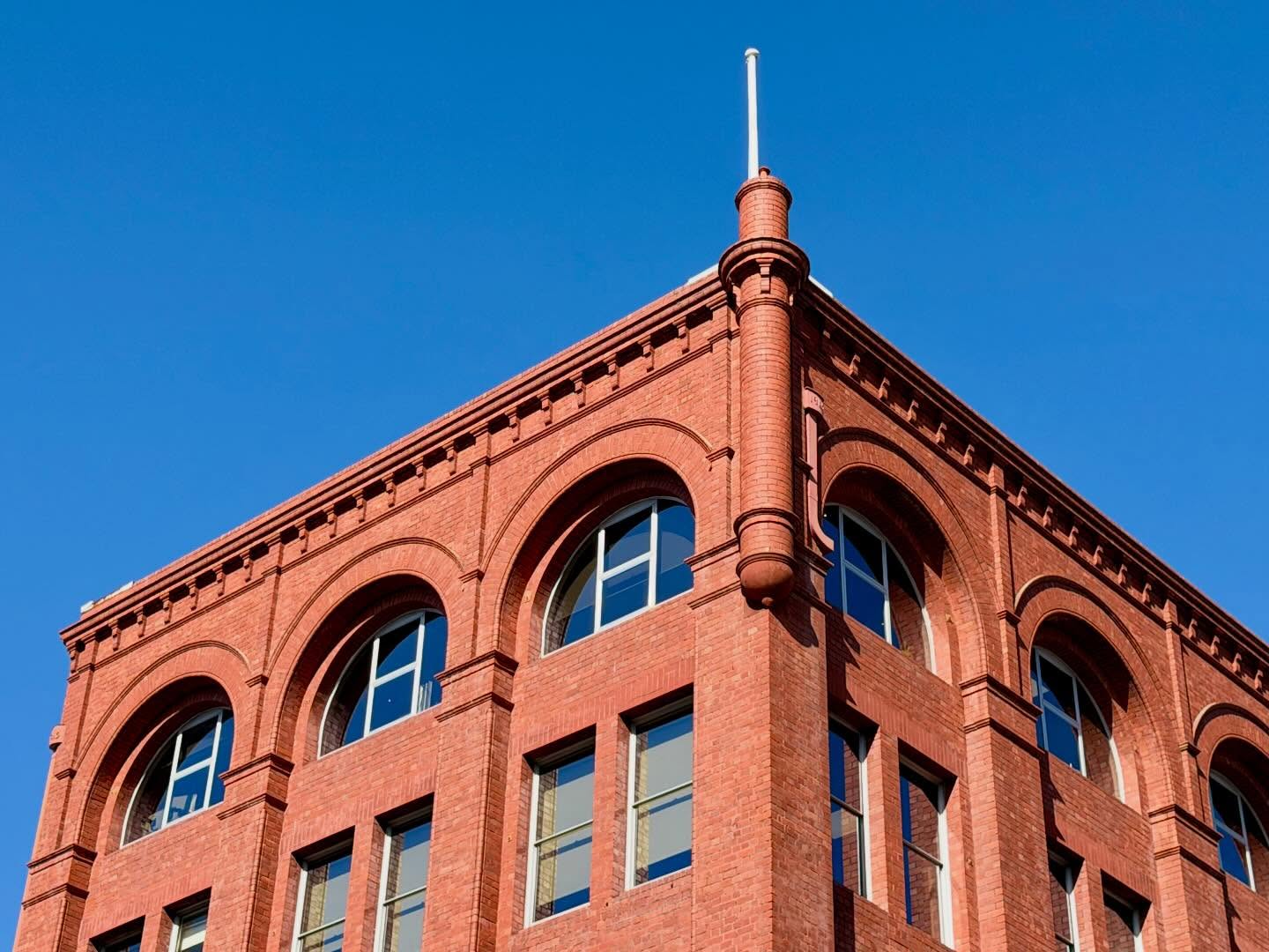 The Dehle, Bennison & Co.’s wholesalers and merchants office/warehouse (1914) on the Collins/Victoria corner, Hobart. A muscular red brick American Romanesque pile: deep, rhythmic recessed arched bays riding on full-height pilasters, with a corner tourelle because why not. Scale, permanence, and business confidence in a port city. Shame about the aluminium windows.