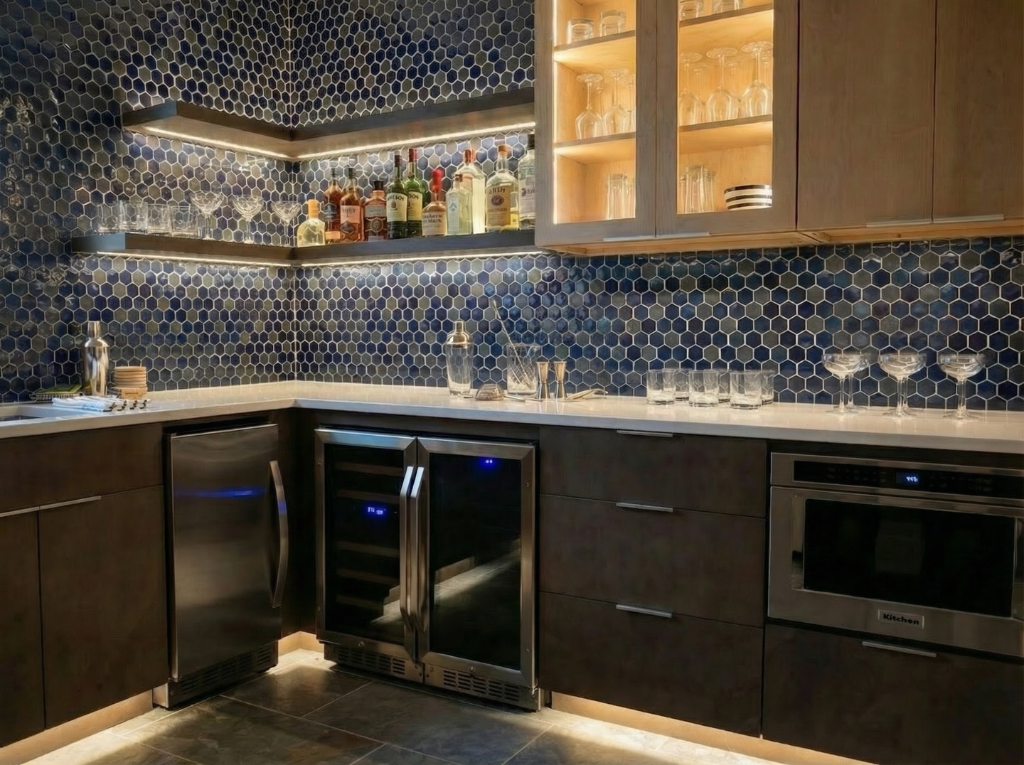 This one’s ready for game day! Our out of town clients wanted a cool space in their lower level so that they can entertain when visiting, especially for game weekends. We wanted it to feel warm and inviting but still have a little edge. These awesome deep blue tiles, wood tones, and moody accent lighting create the perfect vibe. 😎
If you’re thinking about adding a bar for hosting and football weekends, let’s make it happen. Hit us up!