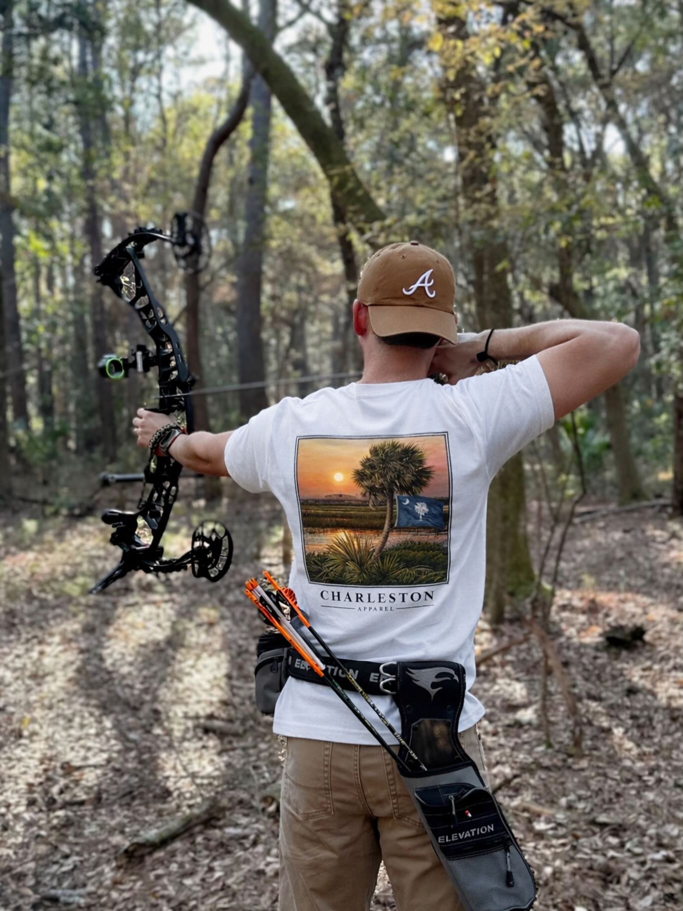 A great day to shoot and wear one of our favorite tees, Palm & Flag! This design is an original hand painting by Charleston local artist, Kevin Curran. Get yours today, link in bio 🤙🏼 #charlestonsc #mountpleasantsc #archery @sweetgrassmercantile