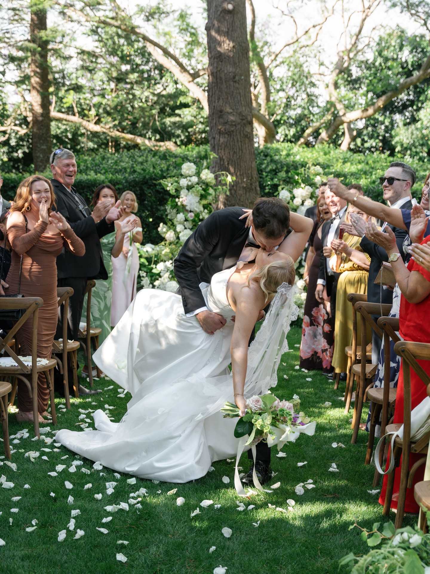 Some ceremony spaces are beautiful on their own but thoughtfully placed florals are what transform them into something truly memorable.
For Georgia & Brayden, the florals were created to frame the couple beneath the cedar tree while keeping the garden feeling open and romantic.
Layered white blooms with accents of pink, soft movement and sculptural pillars created a natural focal point for the ceremony allowing the moment to feel intimate, even within the grandeur of the gardens.
@gabbinbar
@wallflowerweddings