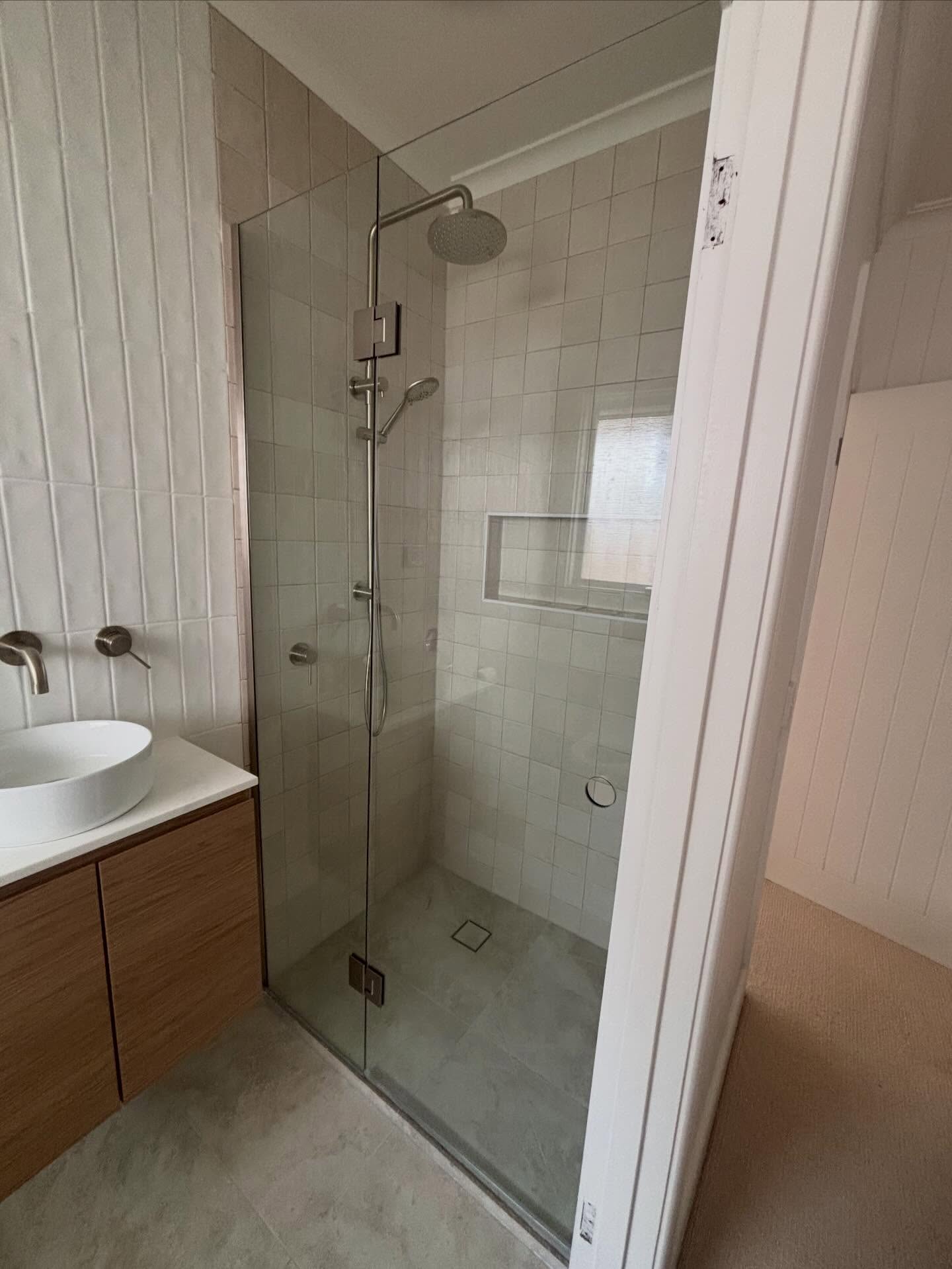 Frameless shower screen installed with brushed nickel hardware in Edithvale.