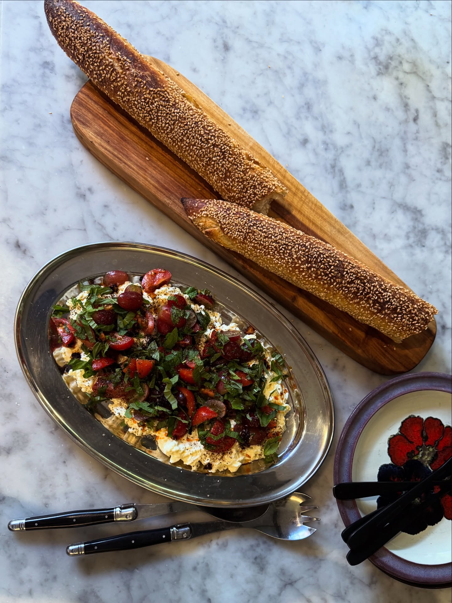 Made a very easy & very delicious starter last night for dinner. It was next level good.
Cherry tomatoes & grapes on stracciatella cheese with crispy chilli oil & fresh herbs.
Ingredients
300g tub of stracciatella cheese
Handful or two red grapes, sliced in half
Handful or two of cherry tomatoes, sliced in half
Handful or two of both mint & basil, thinly shredded
Flakey salt & pepper
Crispy chilli oil
Instructions
Place stracciatella on serving plate. In a separate bowl season the grapes & cherry tomatoes well with flakey salt & lots of freshly cracked pepper add most of the herbs (reserving some for garnish) & mix. Pile grape & tomato mixture on top of the stracciatella, drissle with crispy chilli oil & top with extra herbs & little bit more salt & pepper. Serve immediately with the best crusty bread, I used @bakerbleu sesame ficelle. 🍇🍅