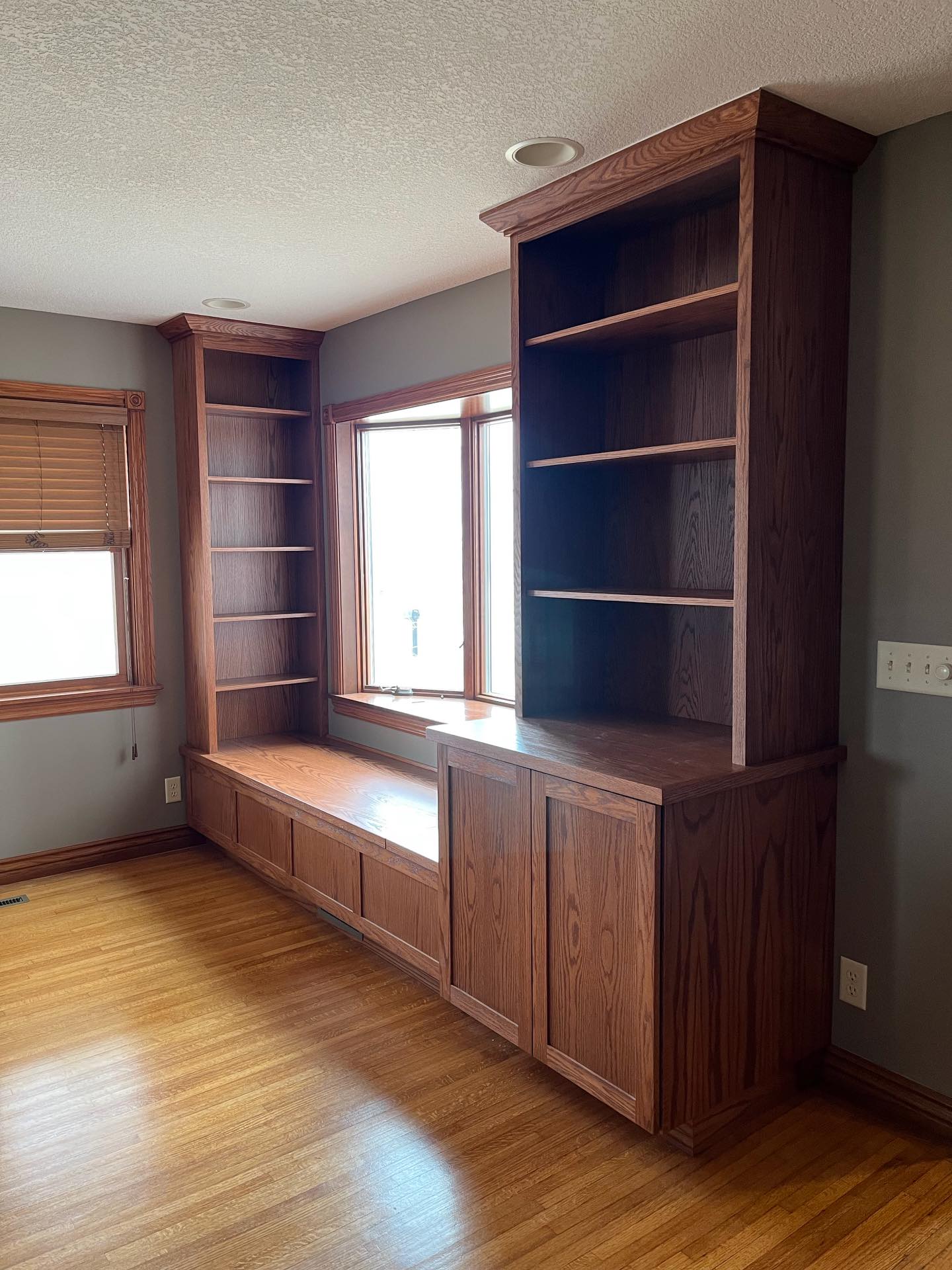 The corner of this living room was designed for a young family with two small children. The window bench creates the perfect sunny spot to sit, read, or sneak in a quiet moment- while the hidden storage below keeps toys tucked away when playtime is over.
Flanked by bookshelves on both sides, this unit gives the family plenty of room for storybooks, keepsakes, and everyday life.
Built for family time, story time, and everything in between.