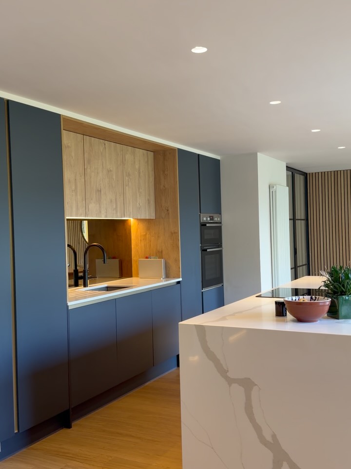 Some kitchens just stop you in your tracks.
With its open space and beautiful natural light, this design feels calm, elegant and effortlessly modern. Deep super matte Indigo Blue cabinetry is balanced with warm Gold Harbour Oak doors and slatted panelling behind the island, bringing depth and texture into the space.
The details elevate everything! Brushed brass handleless trims, a matt black flexi @quooker tap, and an antique mirror splashback that reflects light throughout the room. Finished with Calacatta Gold quartz worktops with waterfall island ends, the result is a kitchen that feels both striking and timeless.
Thoughtfully designed, beautifully built, and made for everyday living.
Kitchen Details
Handleless Super Matte Indigo Blue & Gold Harbour Oak
Calacatta Gold Quartz Worktops – @quartzfabricationsltduk
Antique Mirror Splashback – @the__glasscompany
Matt Black Flexi Quooker Tap & Composite Grey Sink
LED Lighting